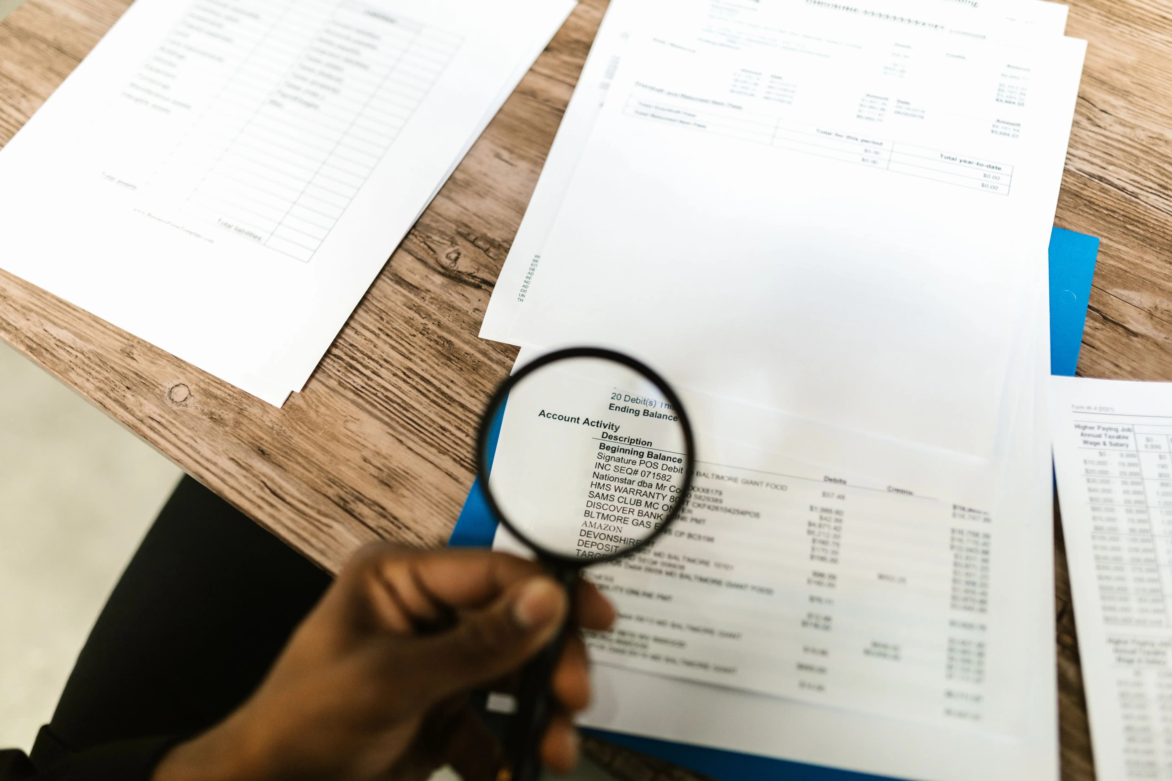A magnifying glass held over a printed document, illustrating close review of transcription accuracy