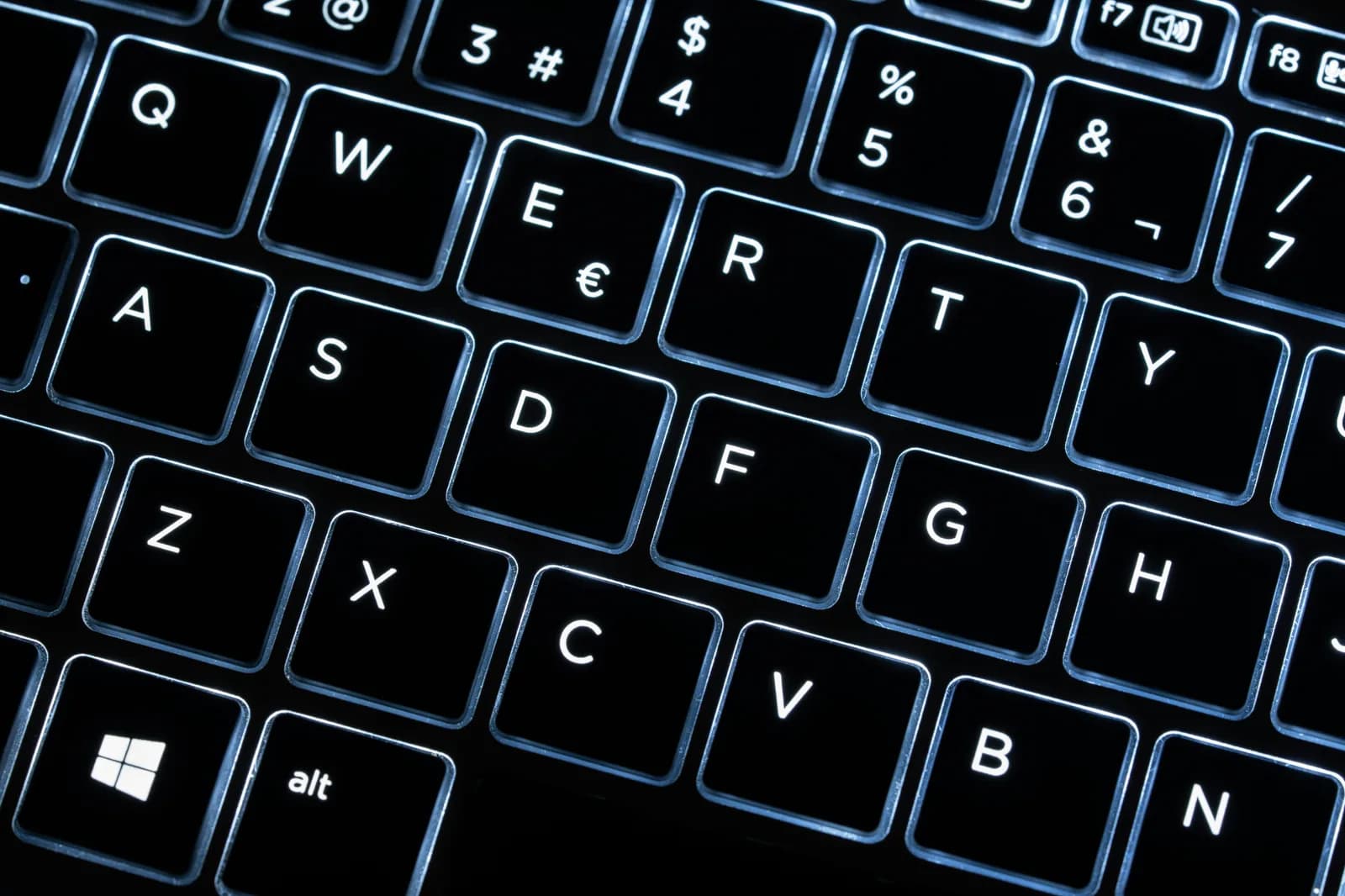 Close-up of an illuminated black desktop keyboard, evoking a full-featured PC command surface