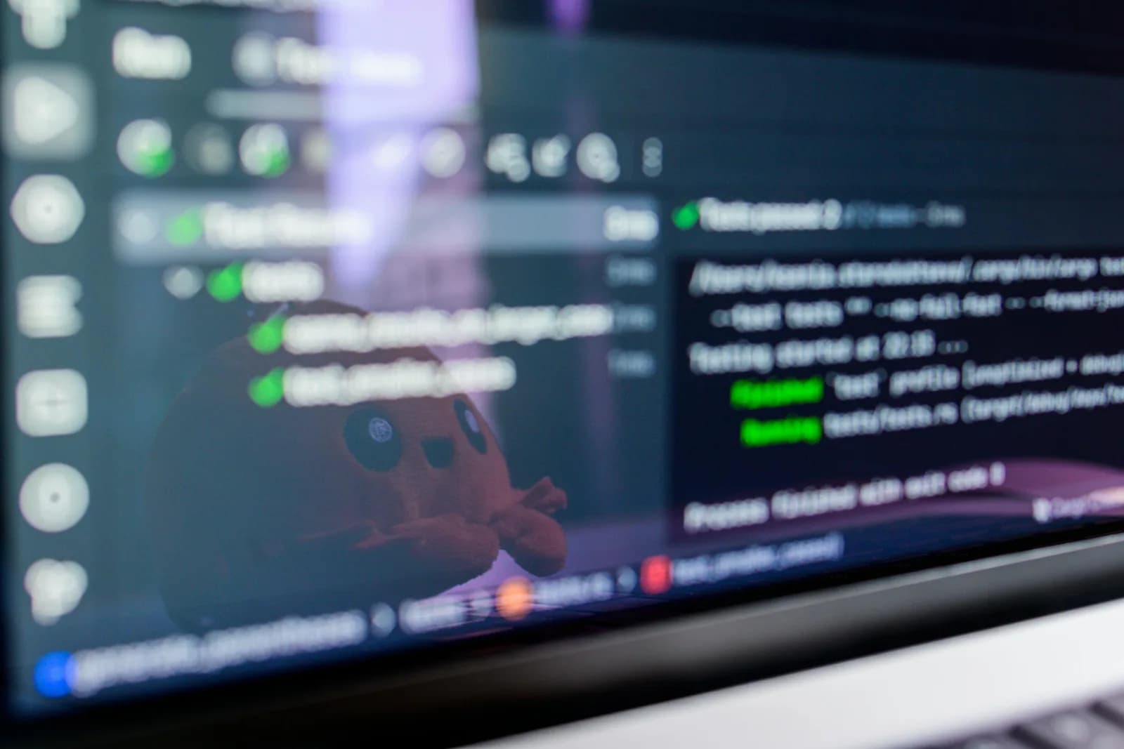 Code and a command-line terminal open on a laptop screen on a clean desk