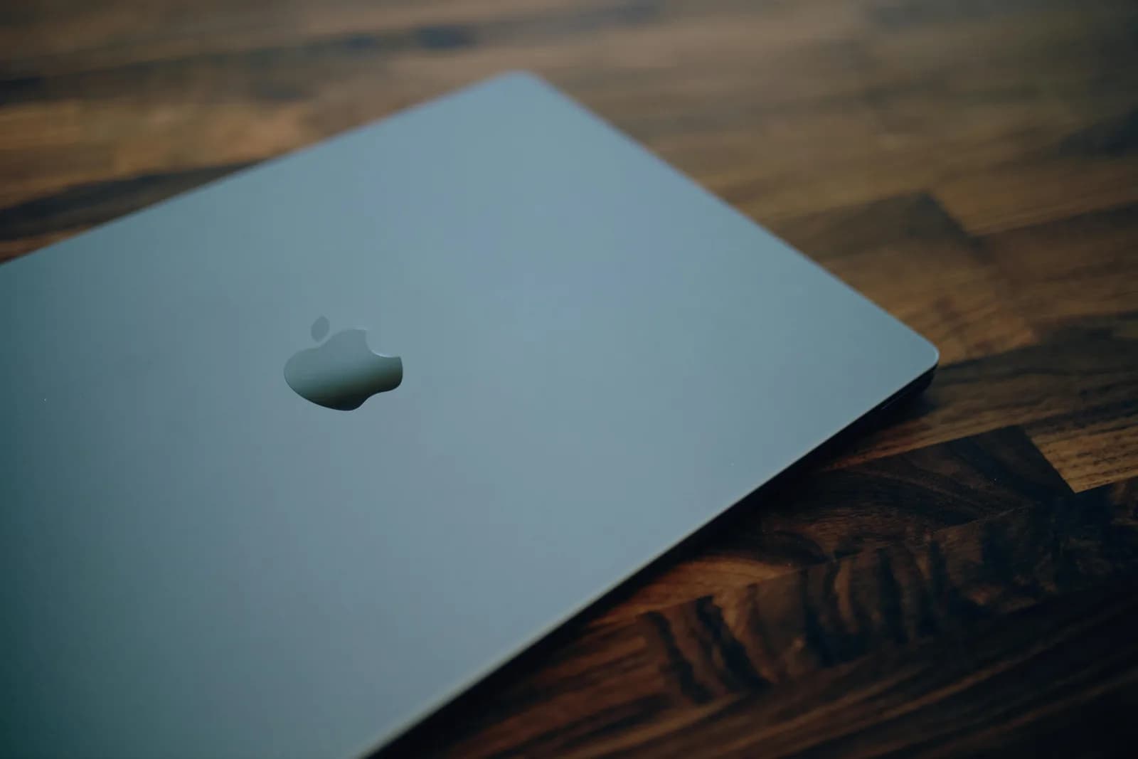 A MacBook on a desk with the fan running warm, evoking a process pinning the CPU