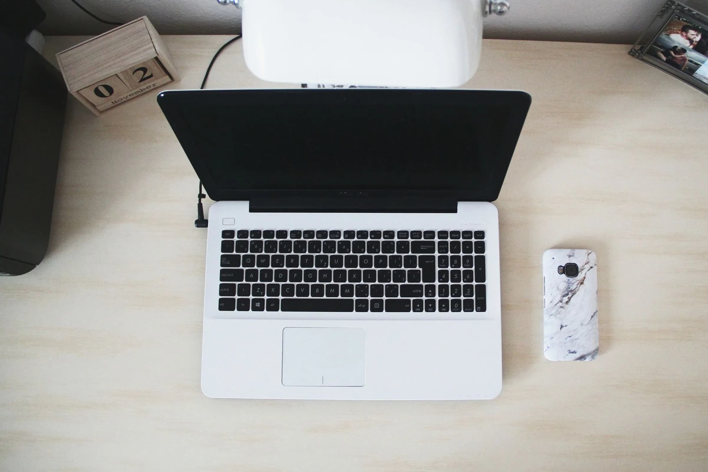 Minimalist desk with keyboard and notepad, evoking a dictation-first writing workflow