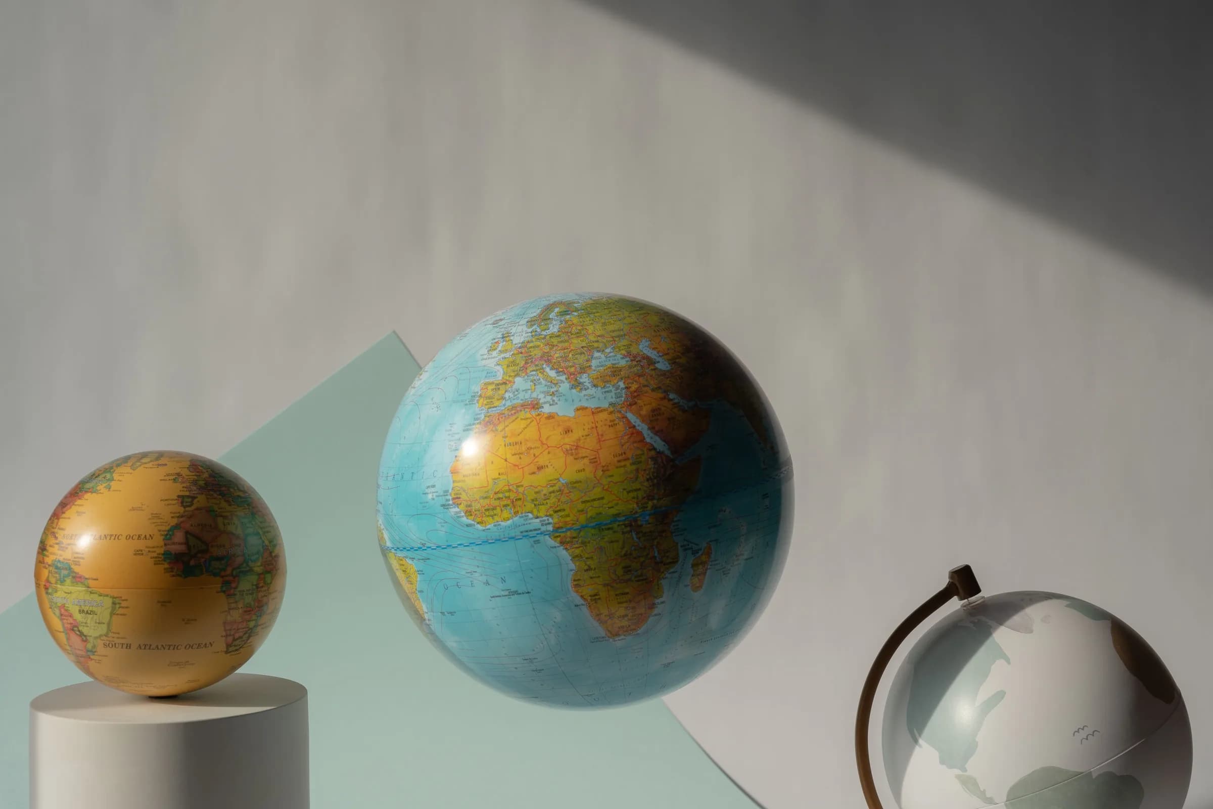 Three world globes floating in a studio setting, evoking multilingual dictation across regions