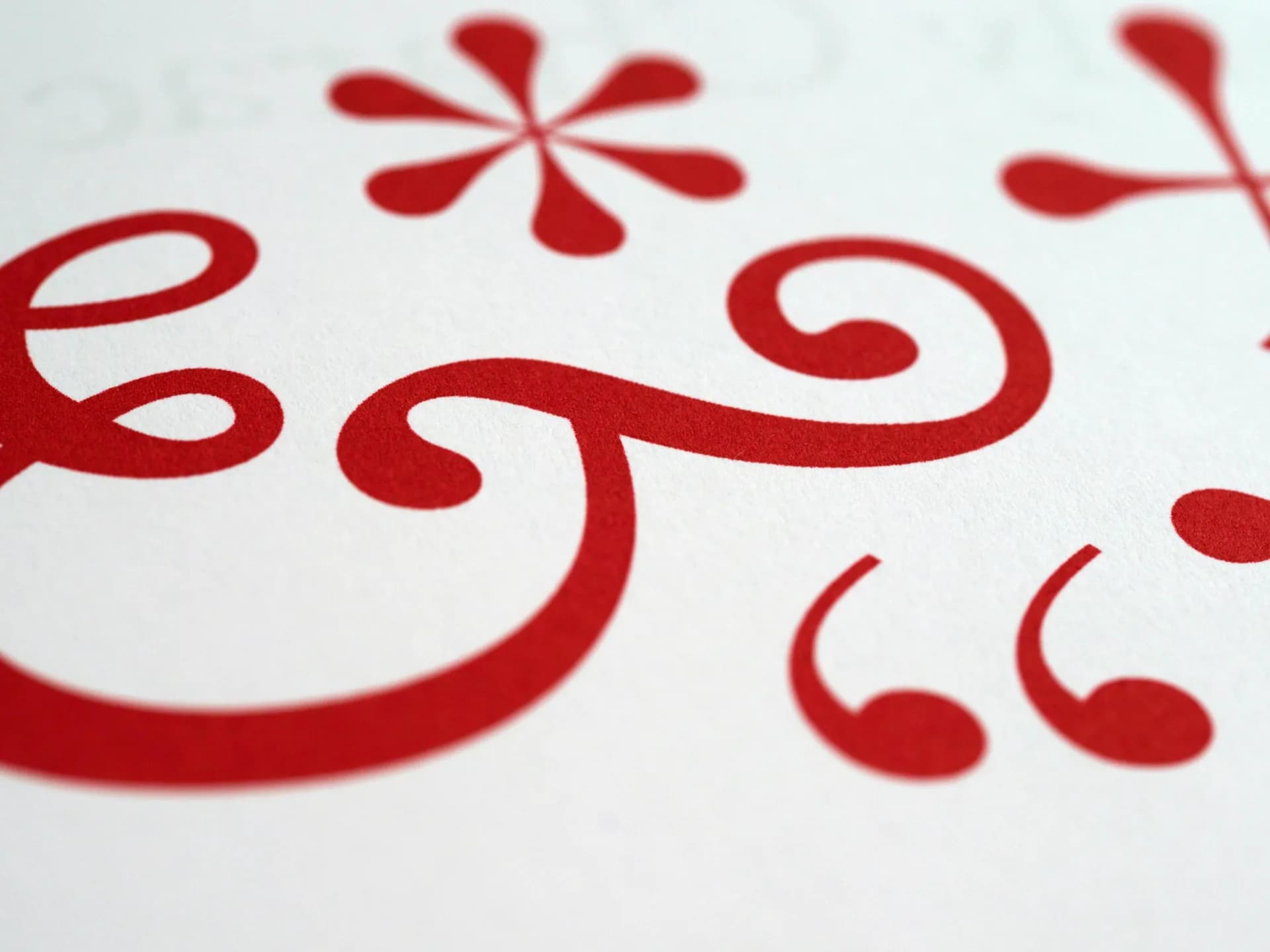 Close-up of red typography punctuation symbols on white paper, evoking missing marks in dictated text