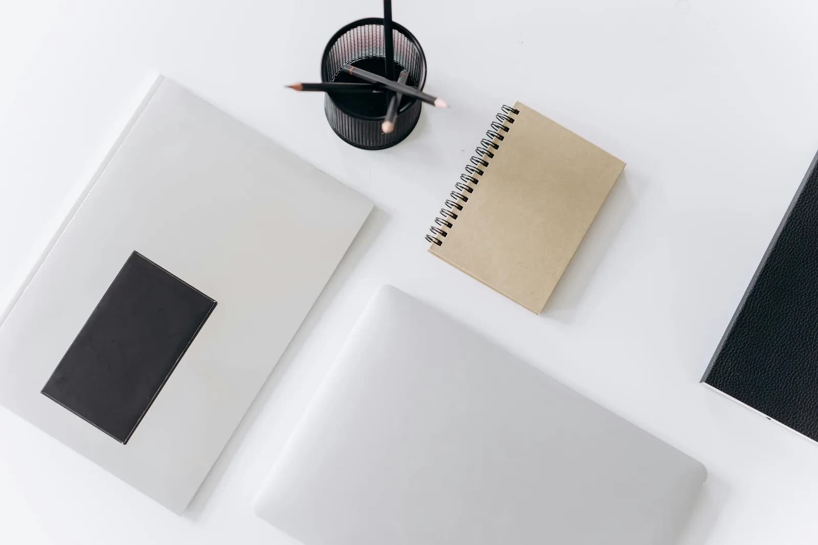 A clean desk with a laptop and a closed notebook, suggesting administrative and personal writing
