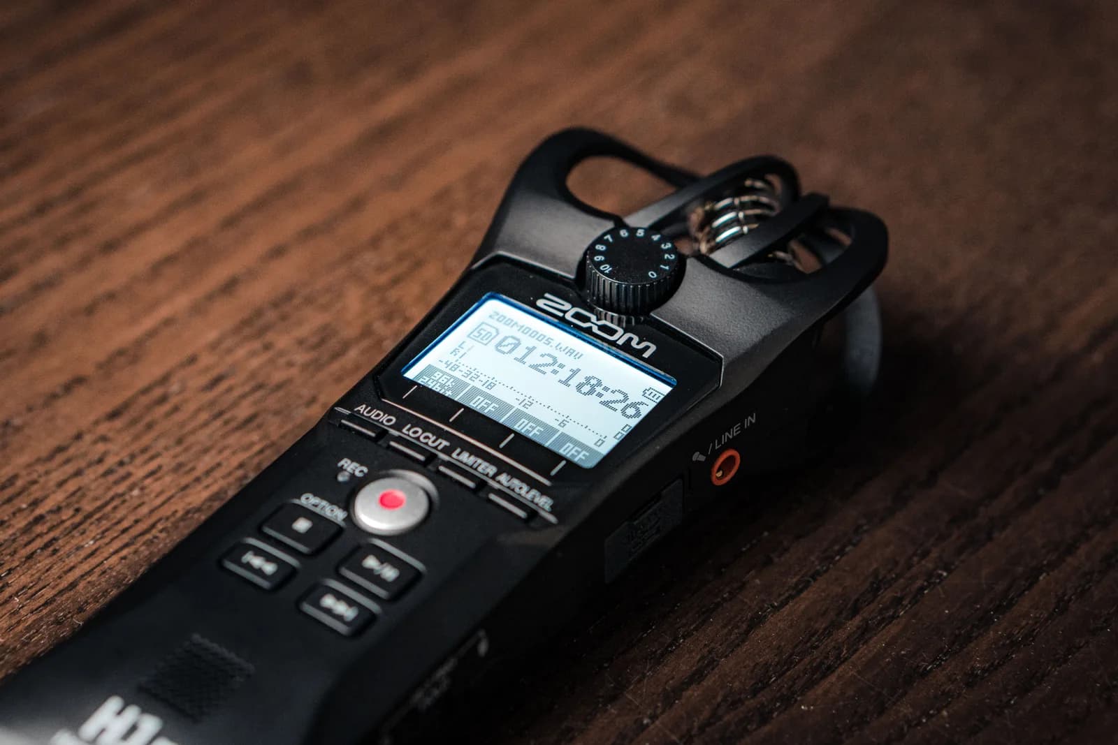 Handheld audio recorder and a microphone on a table, suggesting interview and field recording