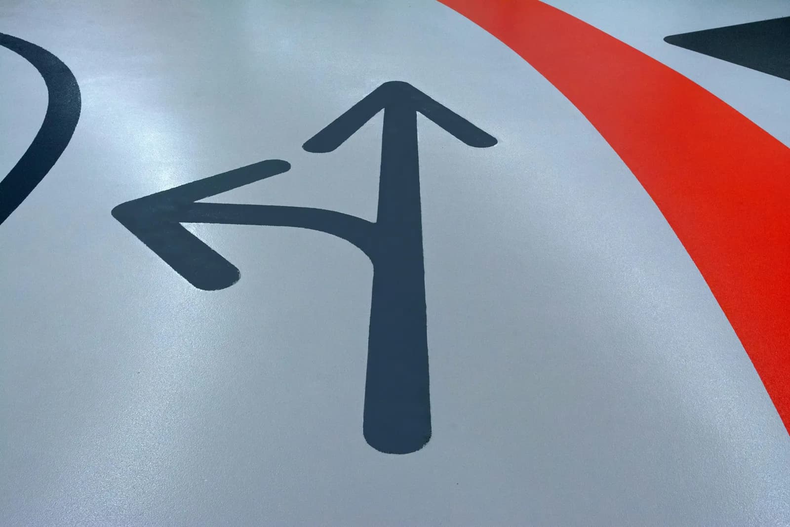 Two arrows painted on a road pointing in different directions, illustrating a choice between tools
