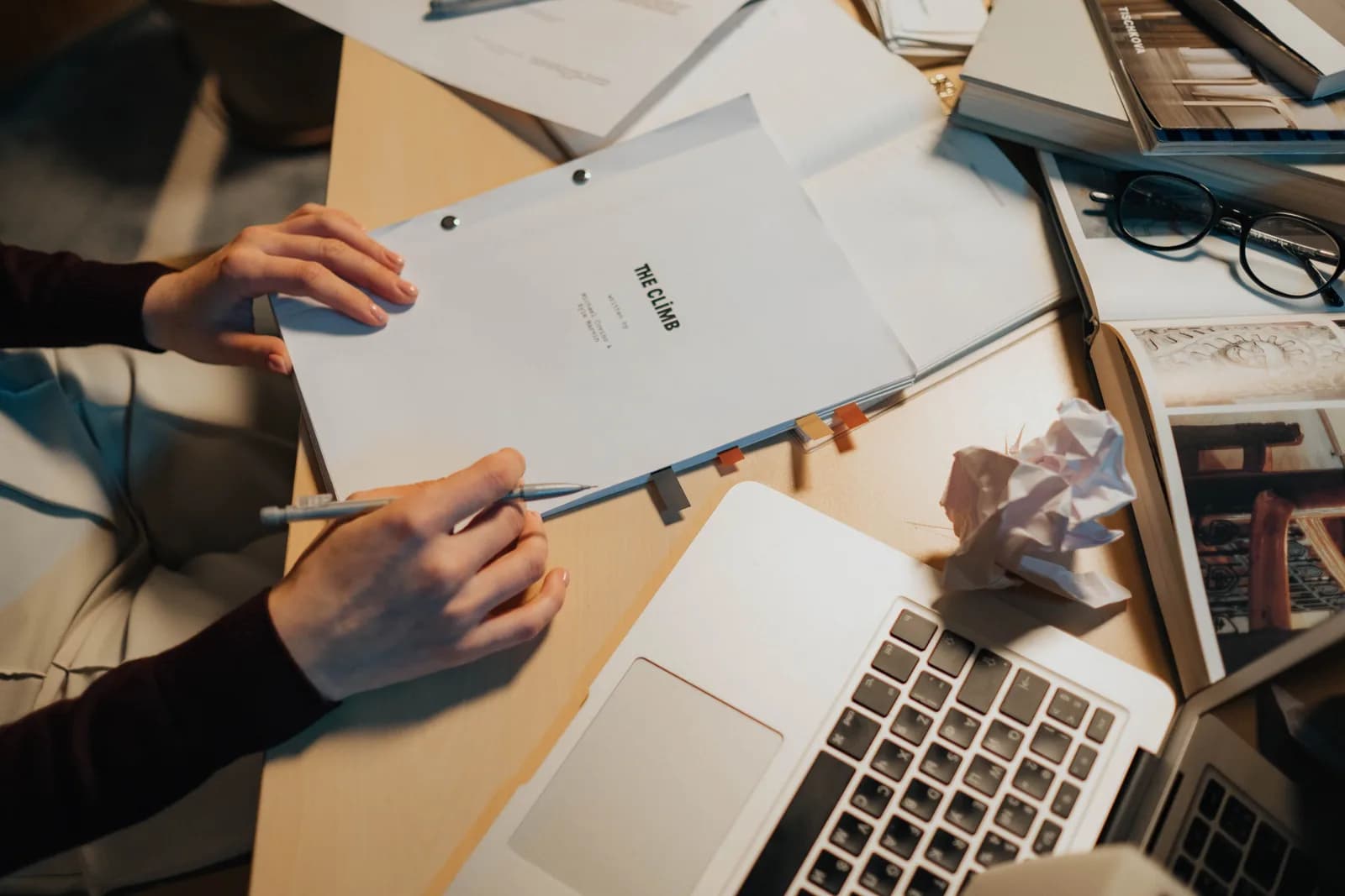Printed screenplay pages and a pen on a dark desk, evoking script writing and dictation