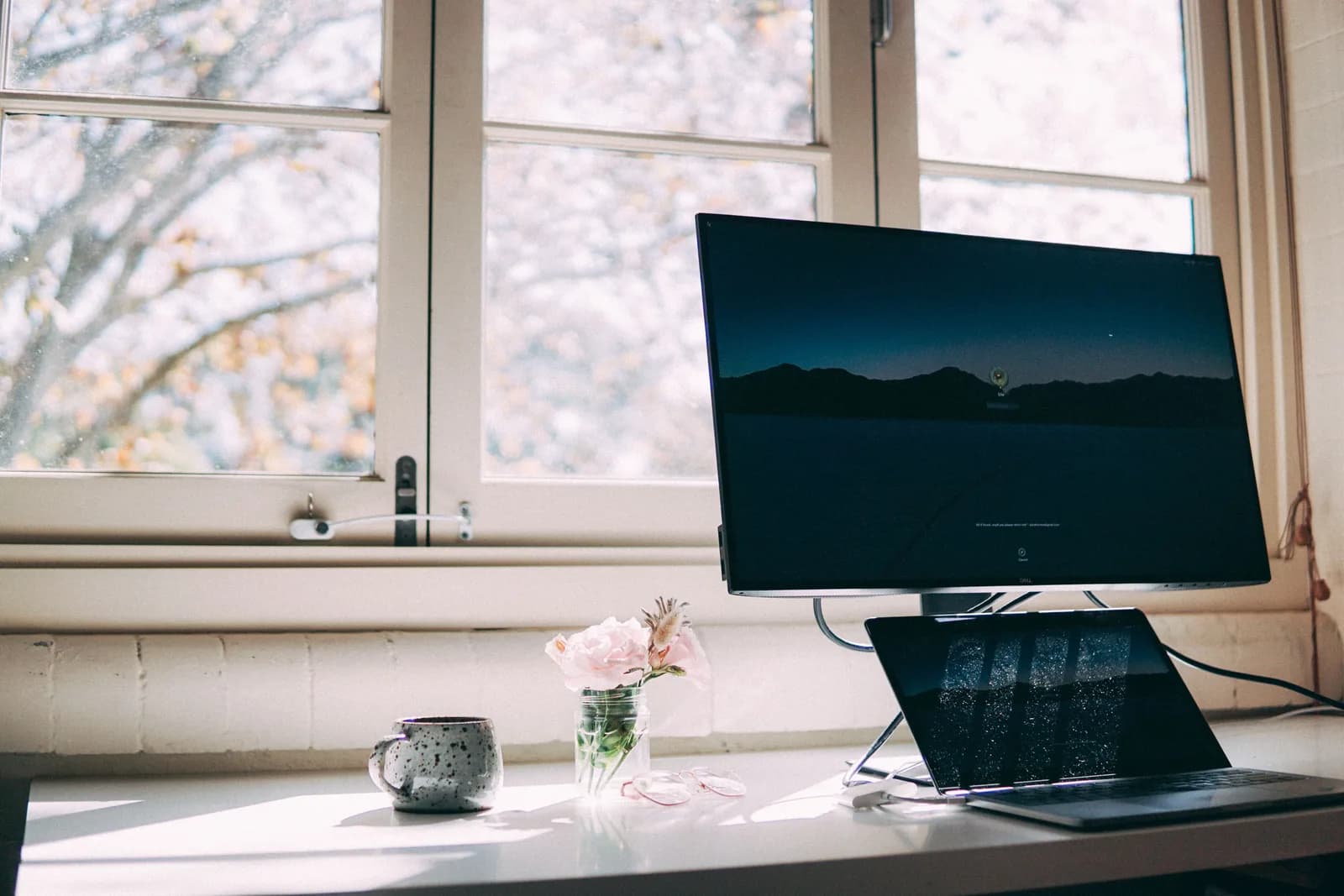A warm, tidy home desk with a laptop and a mug, no people, suggesting comfortable everyday writing