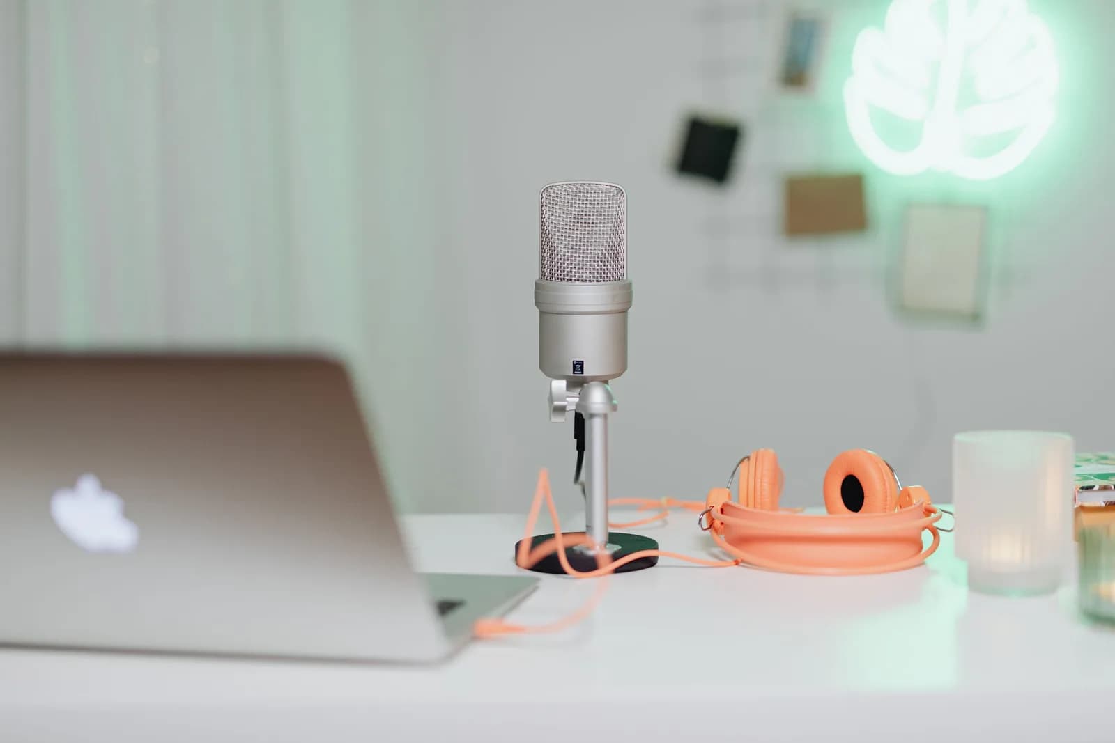 Desk setup with a condenser microphone, laptop and headphones, the dictation input source