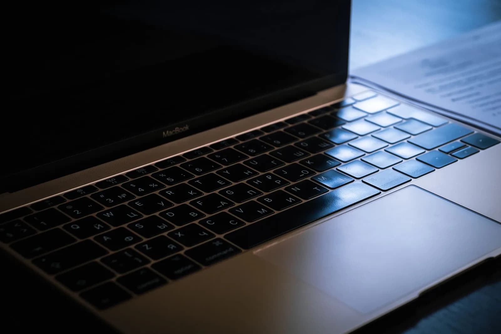 Laptop keyboard under ambient lighting, illustrating where mistyped dictation lands