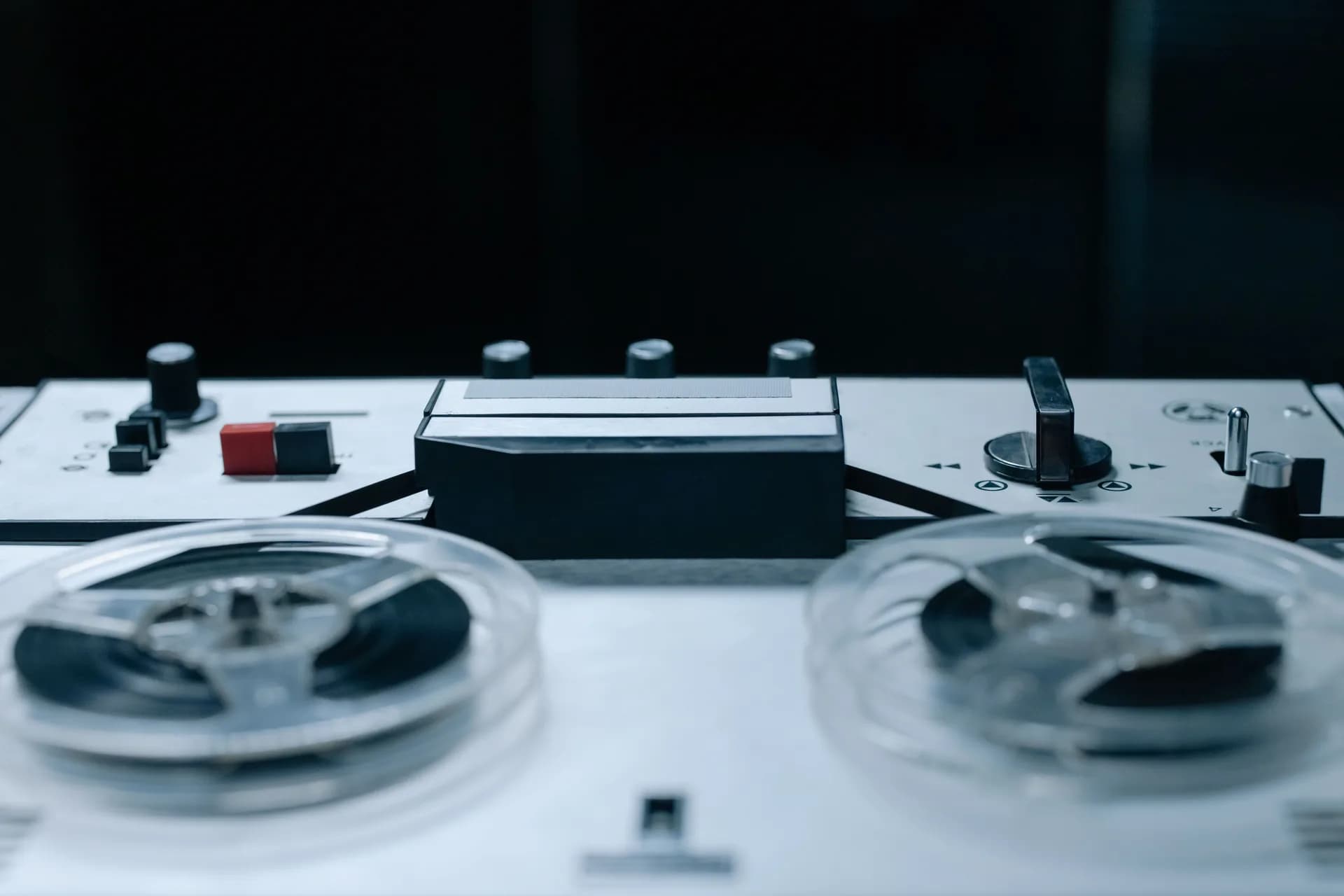 Close-up of a reel-to-reel audio recorder with control buttons, illustrating record-and-transcribe tools