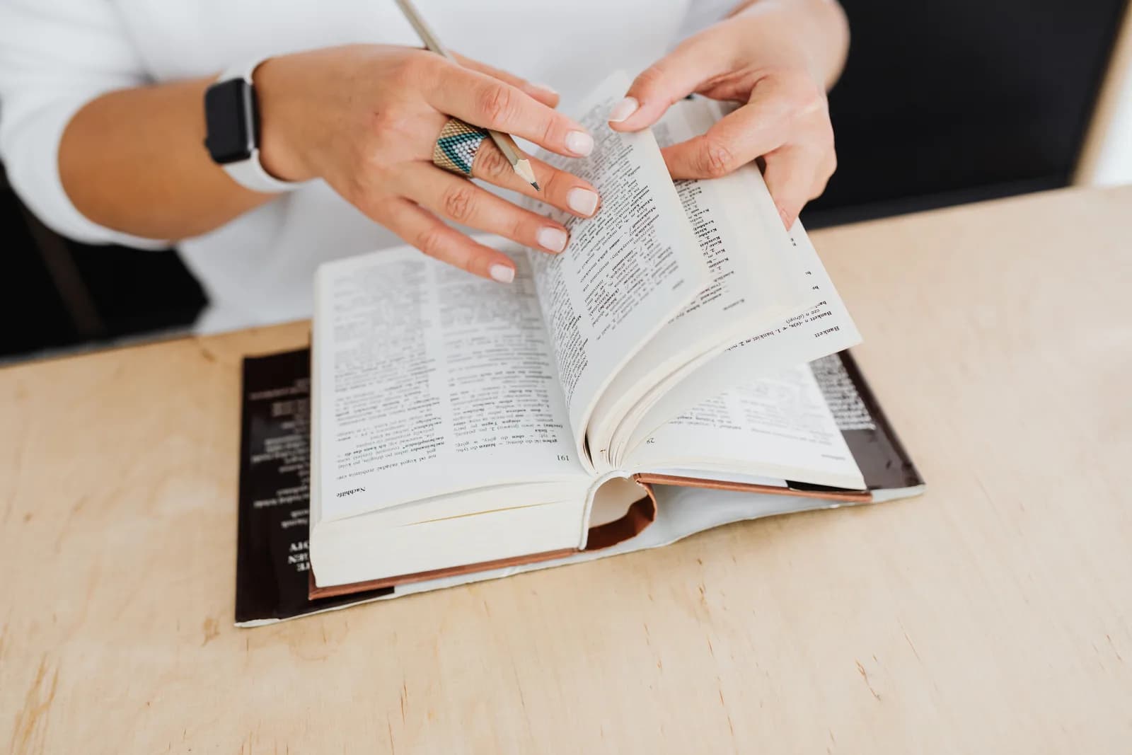 Open dictionary on a desk beside a keyboard, evoking words and vocabulary