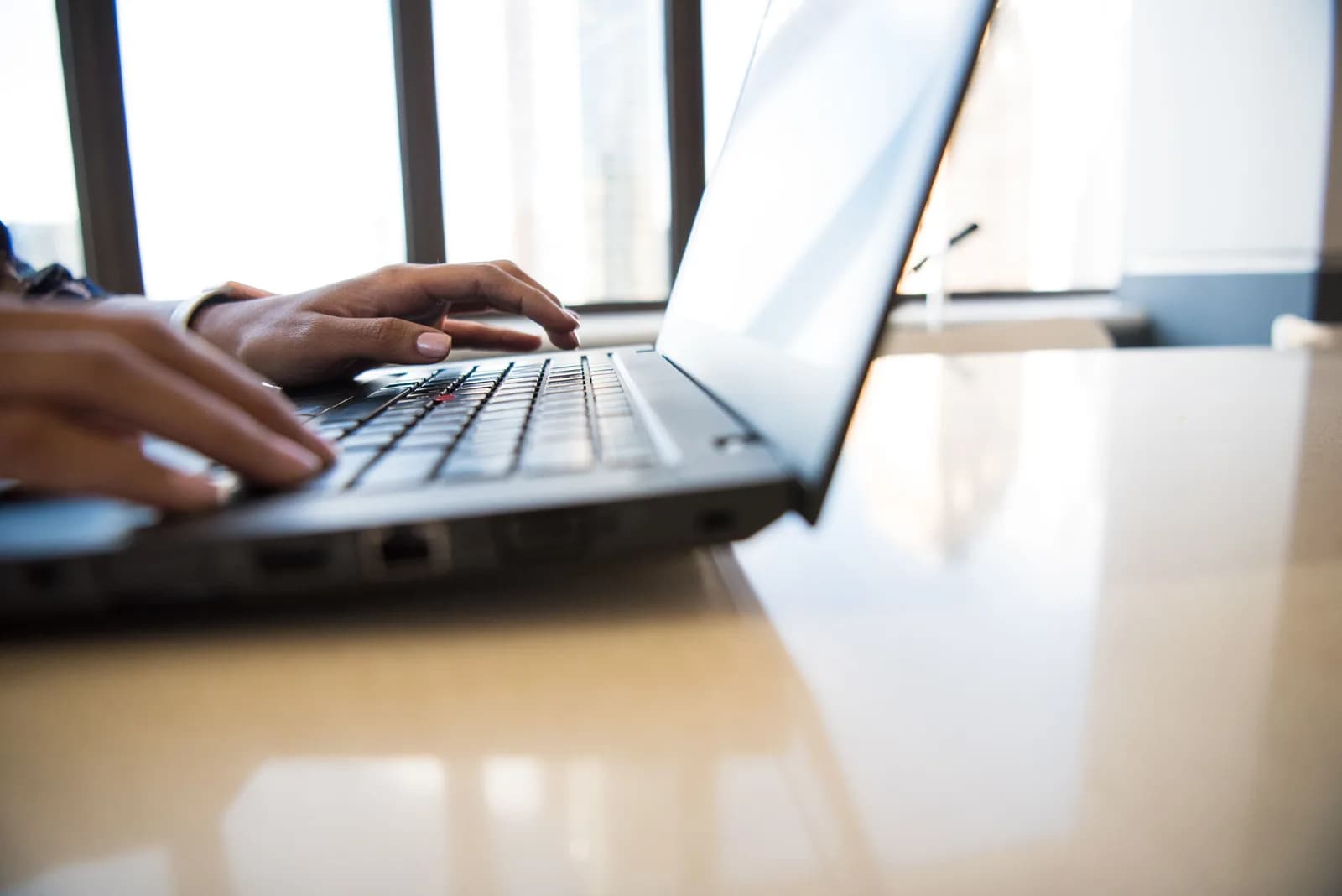 A Windows laptop and keyboard on a desk, ready for hands-free typing by voice