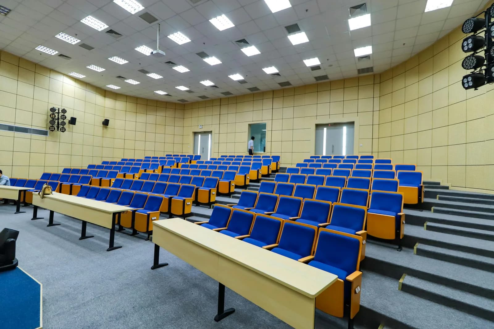 Empty university lecture hall with tiered seating and a whiteboard, evoking study and note-taking