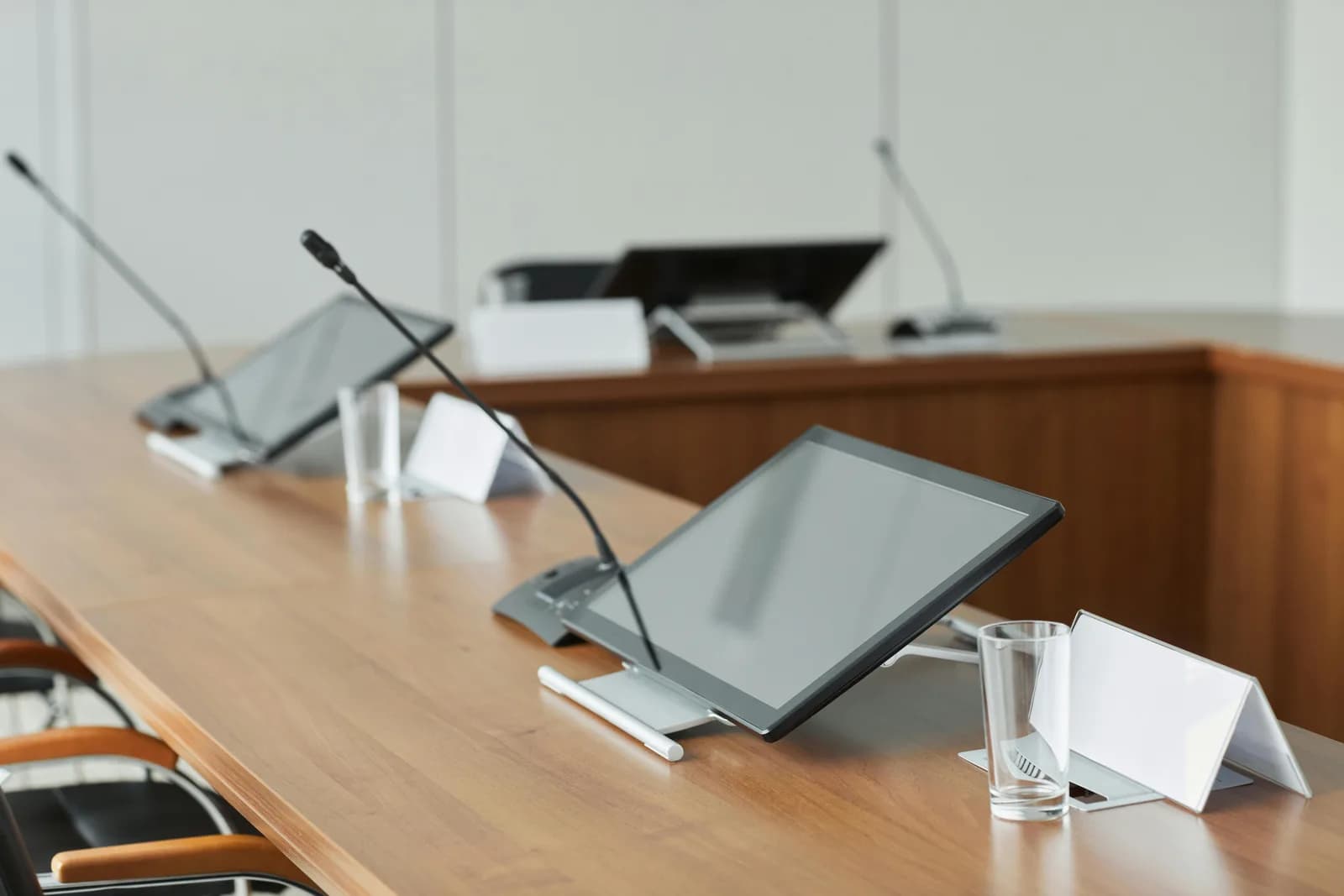Studio monitors and a microphone on a wooden desk, evoking voice and audio tools