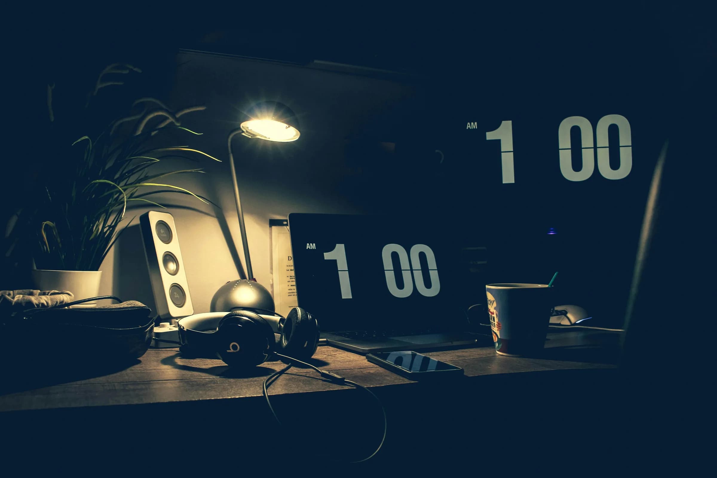 Dimly lit desk at night with a laptop and headphones, a quiet workspace for dictation that runs entirely on the machine