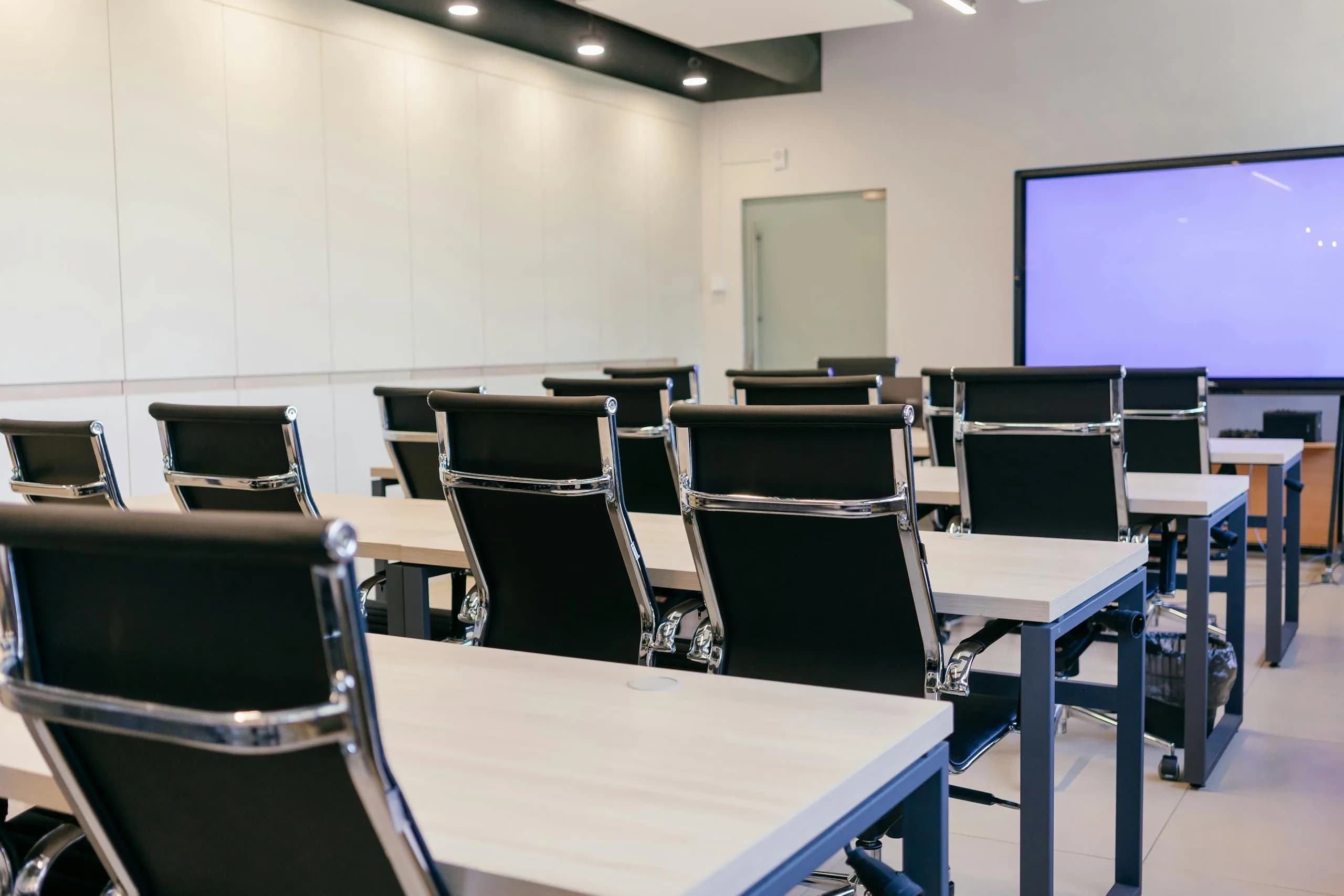Spacious modern conference room with a projection screen, the meeting setting where live captions are used