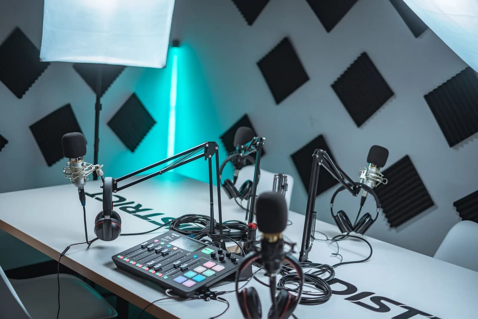 Podcast studio setup with microphones, an audio mixer, and acoustic panels for recorded media