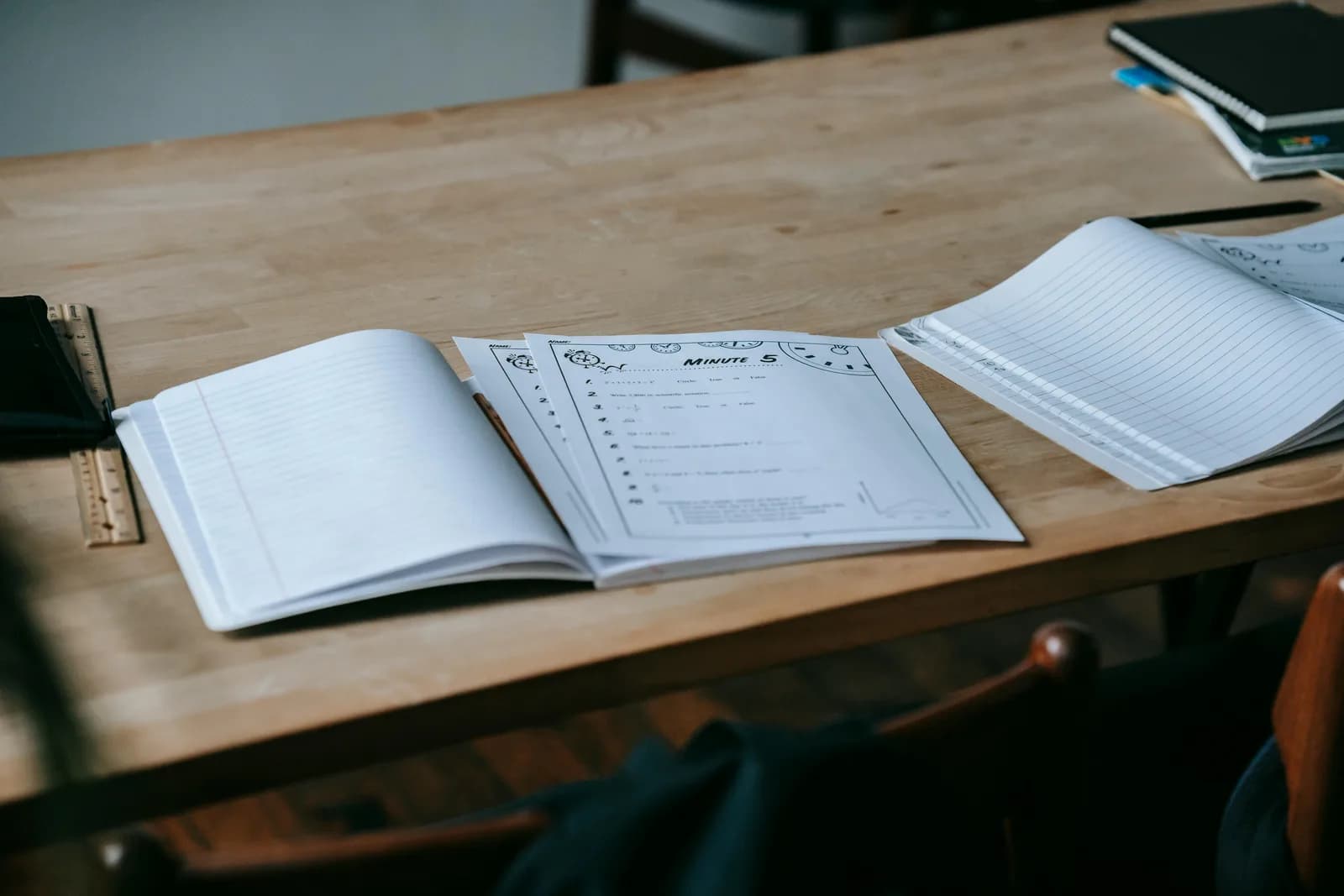 An open language textbook and notebook beside a laptop on a wooden desk