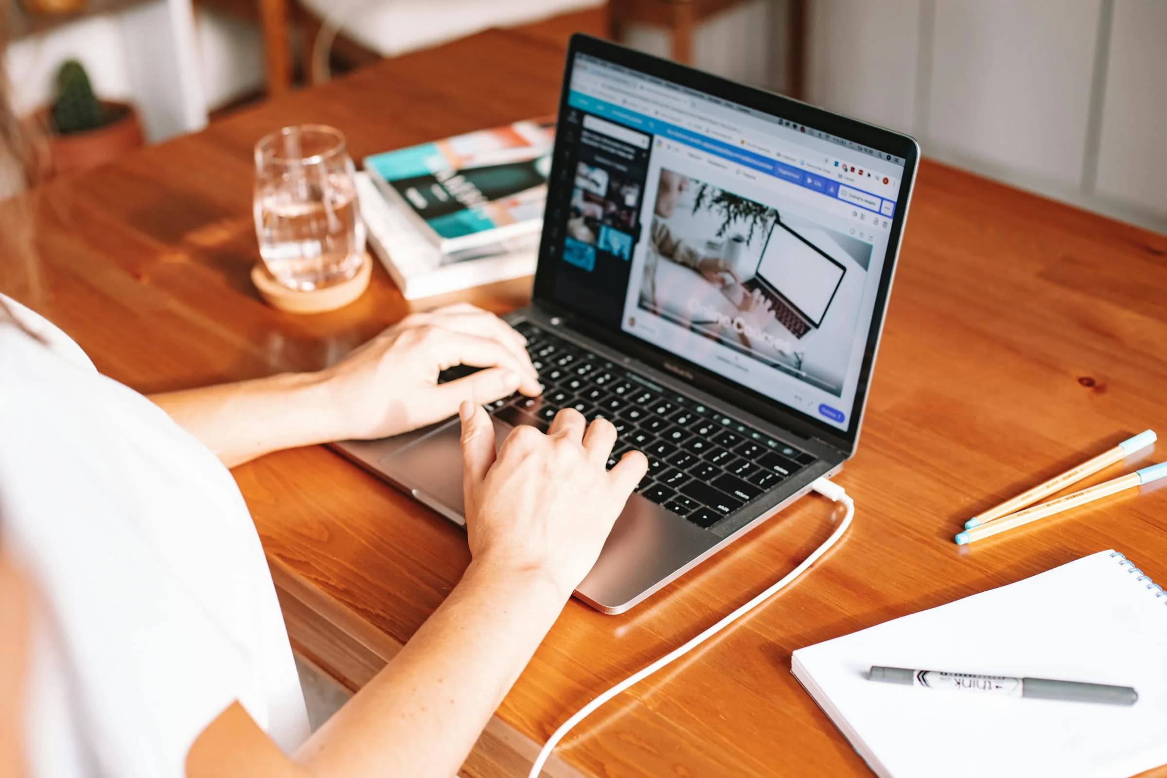 Laptop and notepad on a wooden desk, a low-stakes workspace where built-in dictation is fine