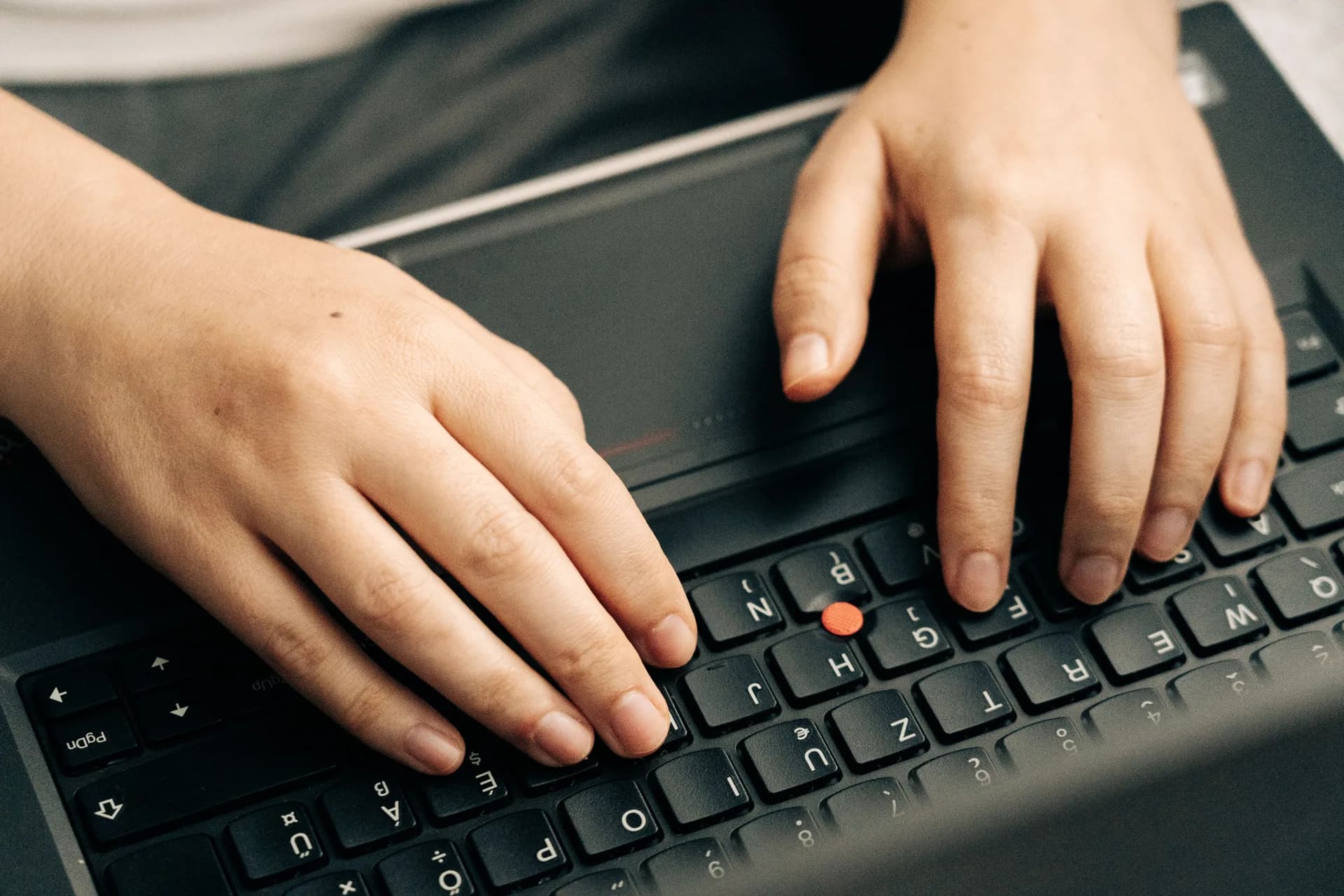 Hands typing on a dark laptop keyboard, framing the move from a browser dictation tool to a desktop one