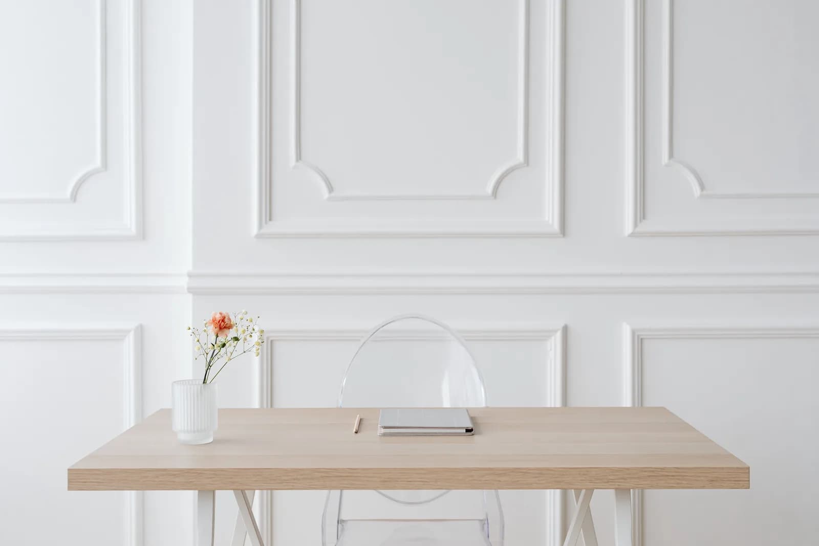 Elegant minimalist workspace with a wooden desk and glass vase, a light and simple scene