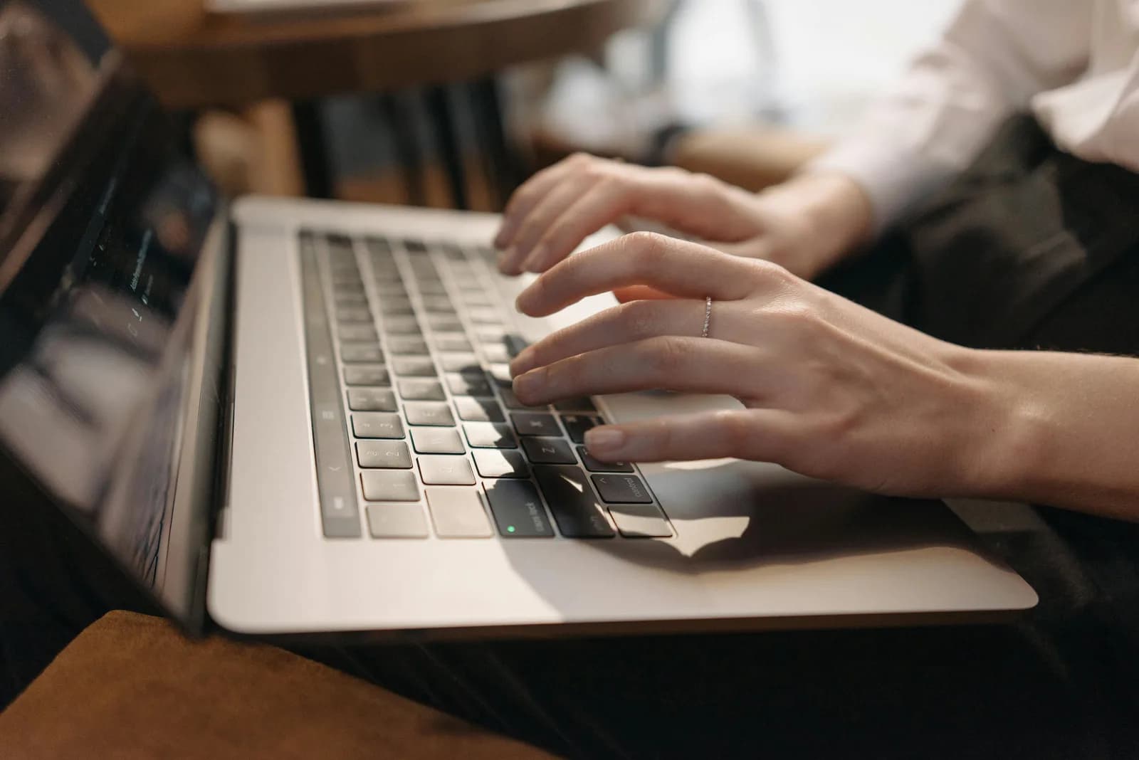 Open laptop beside a notebook and pen on a desk, copying text out of one app into another