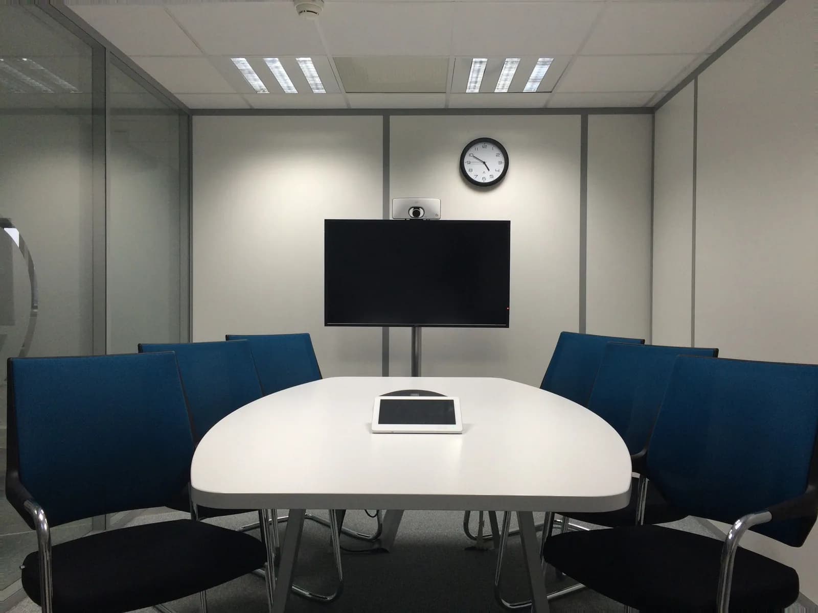 Empty conference room with microphones and monitors set up for recorded video meetings