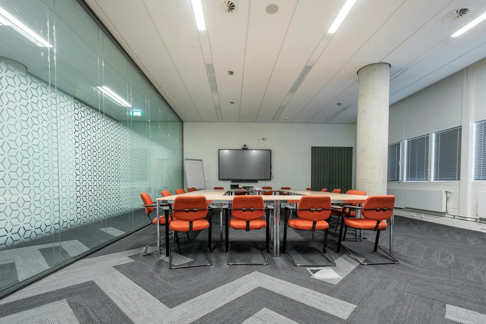 Conference room with glass walls and a long table ready for a meeting
