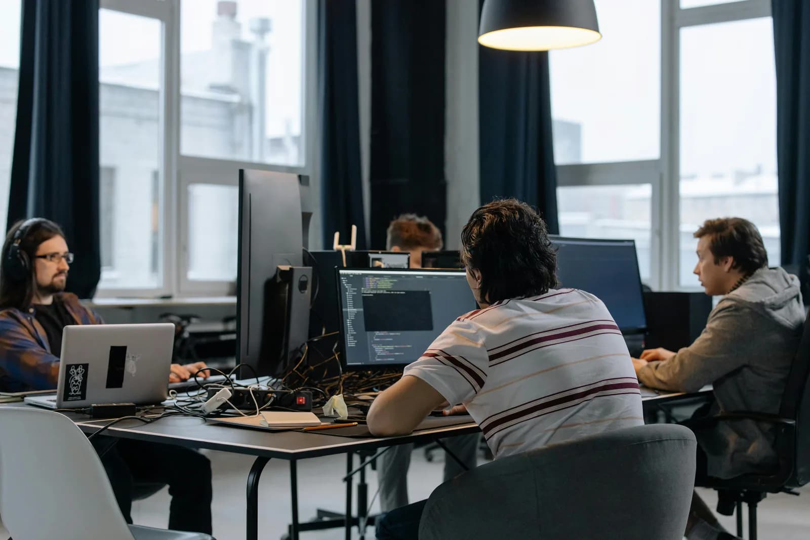 A team working at computers in a modern office, illustrating shared project workflows