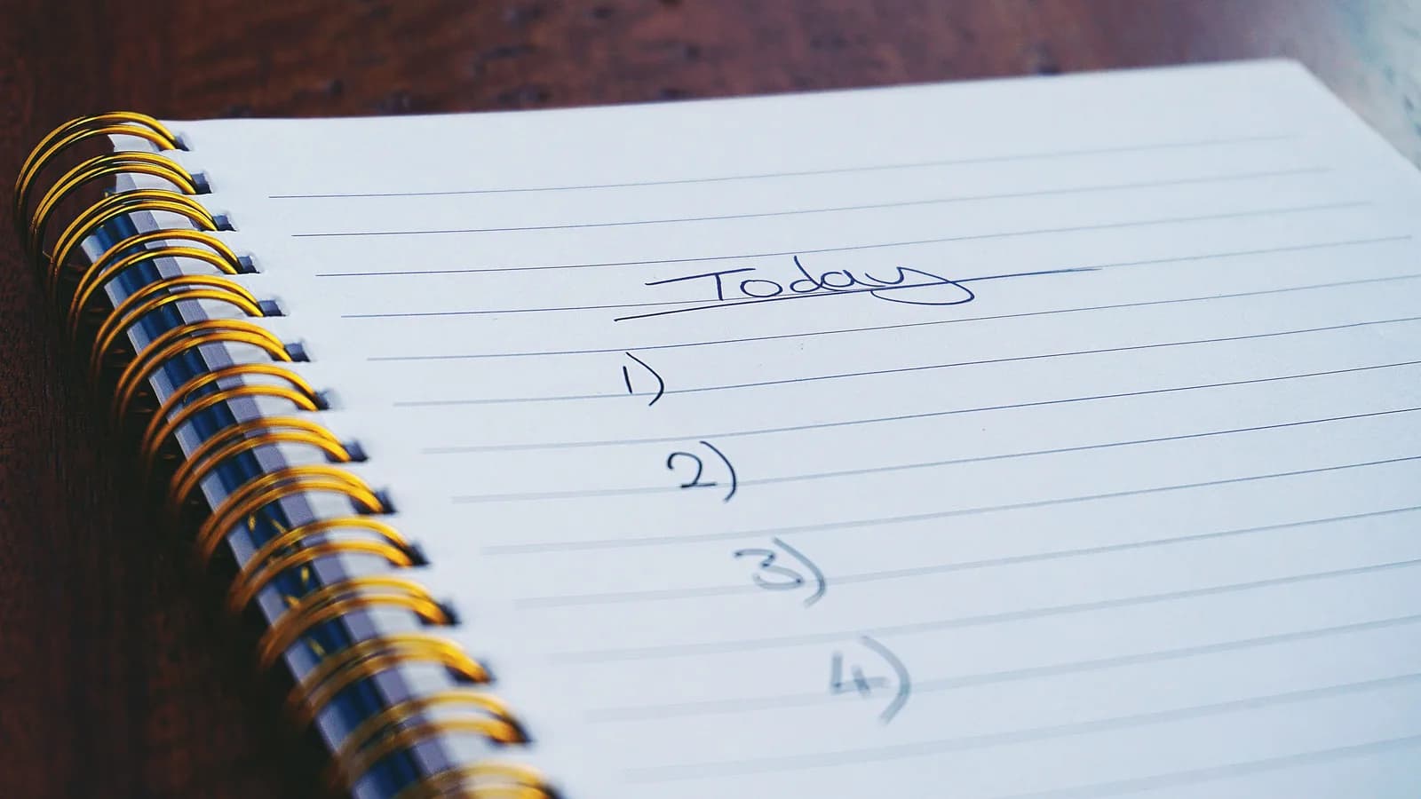 Close-up of a handwritten numbered to-do list in a spiral notebook, standing in for typed task entry