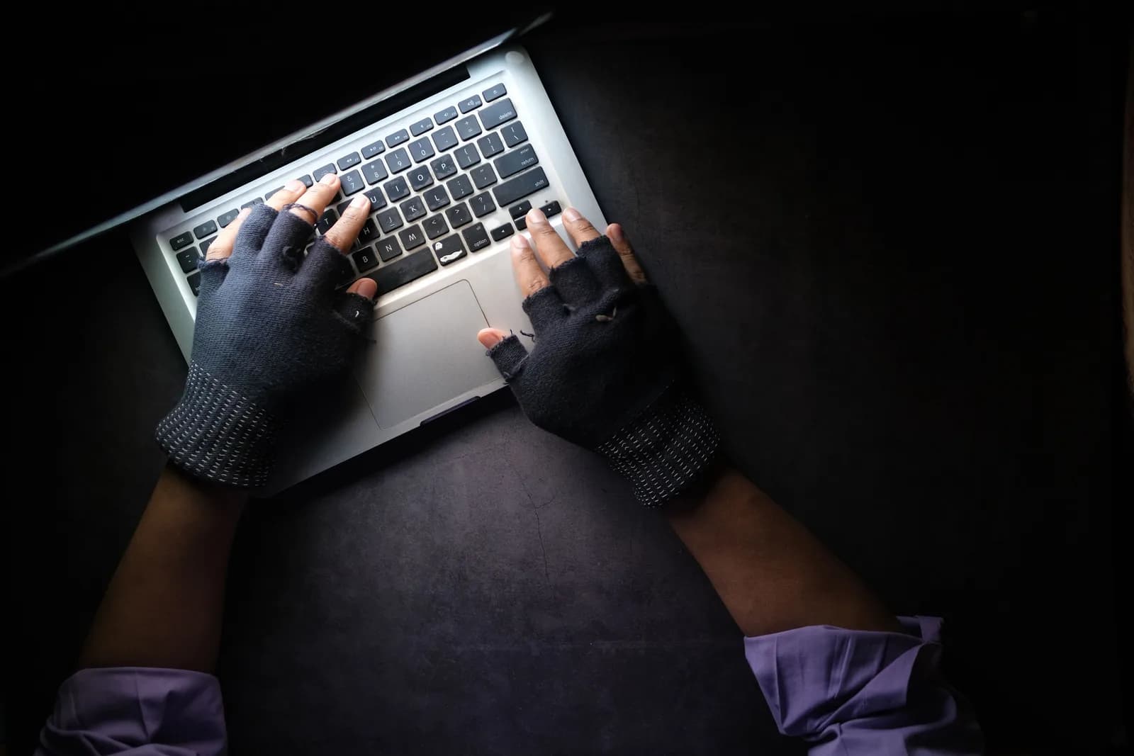 Hands resting beside a keyboard on a calm, tidy desk, suggesting taking a break from typing