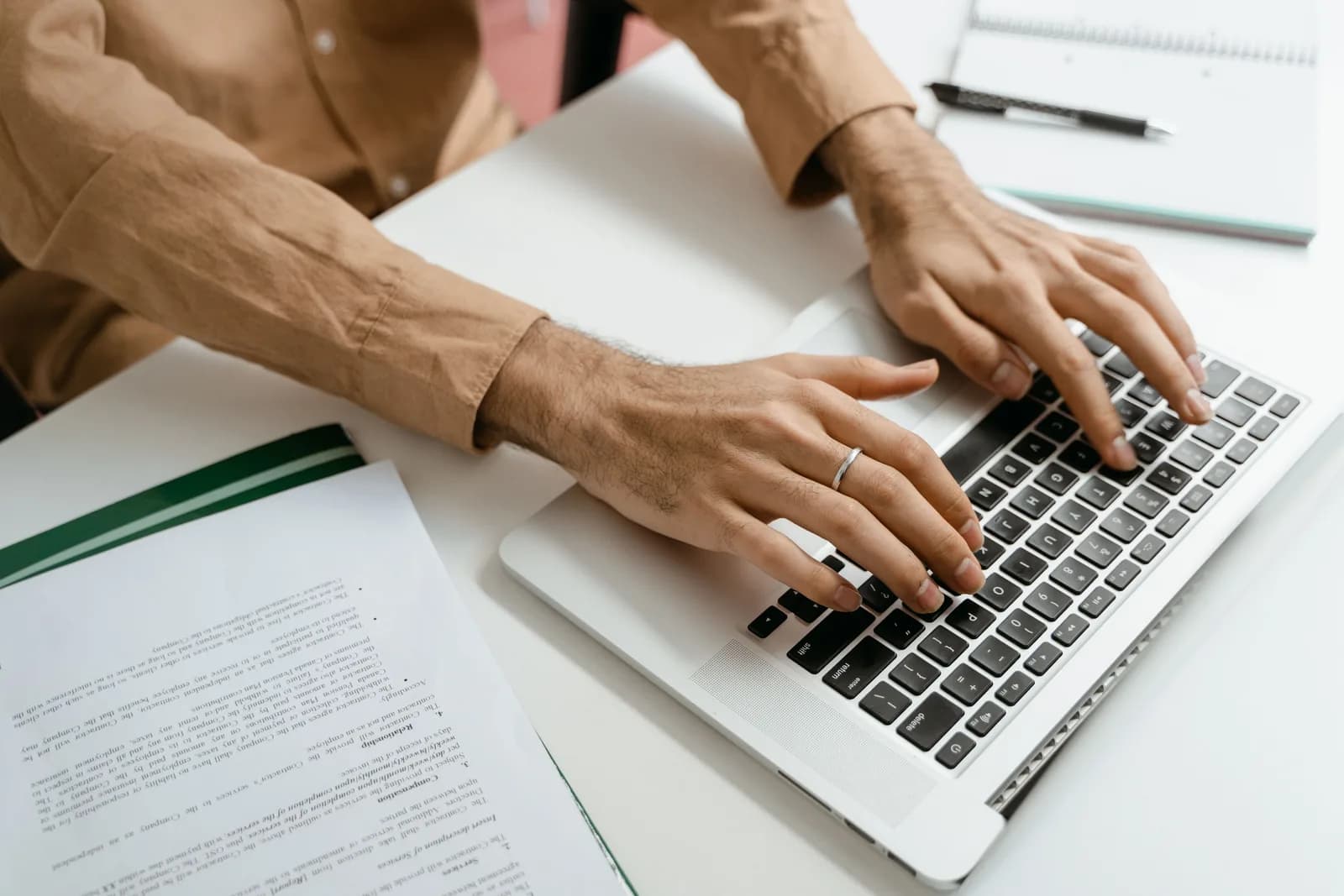 Person drafting a long article on a laptop keyboard, contrasting typing with dictation