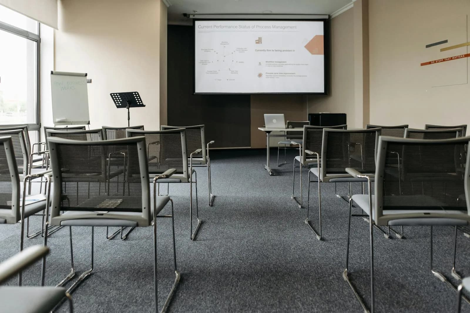 Empty conference room with a blank projector screen ready for a slide presentation
