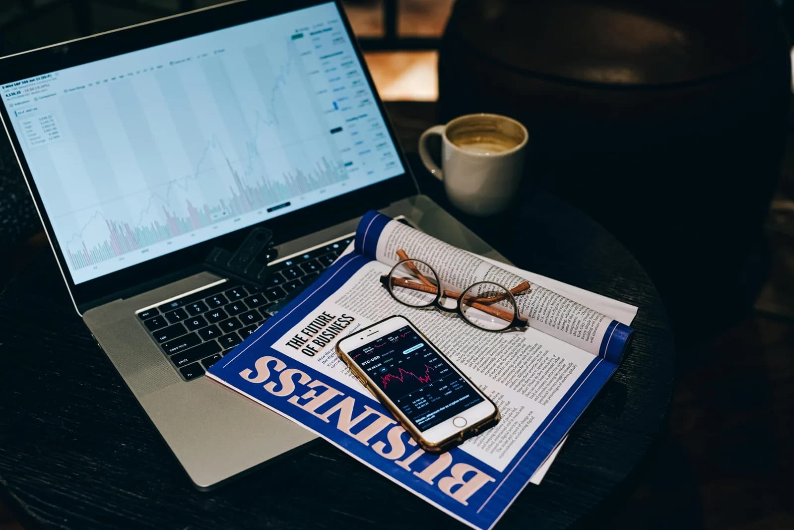 A desk with a laptop, a phone, and a coffee cup, evoking task capture and dictation