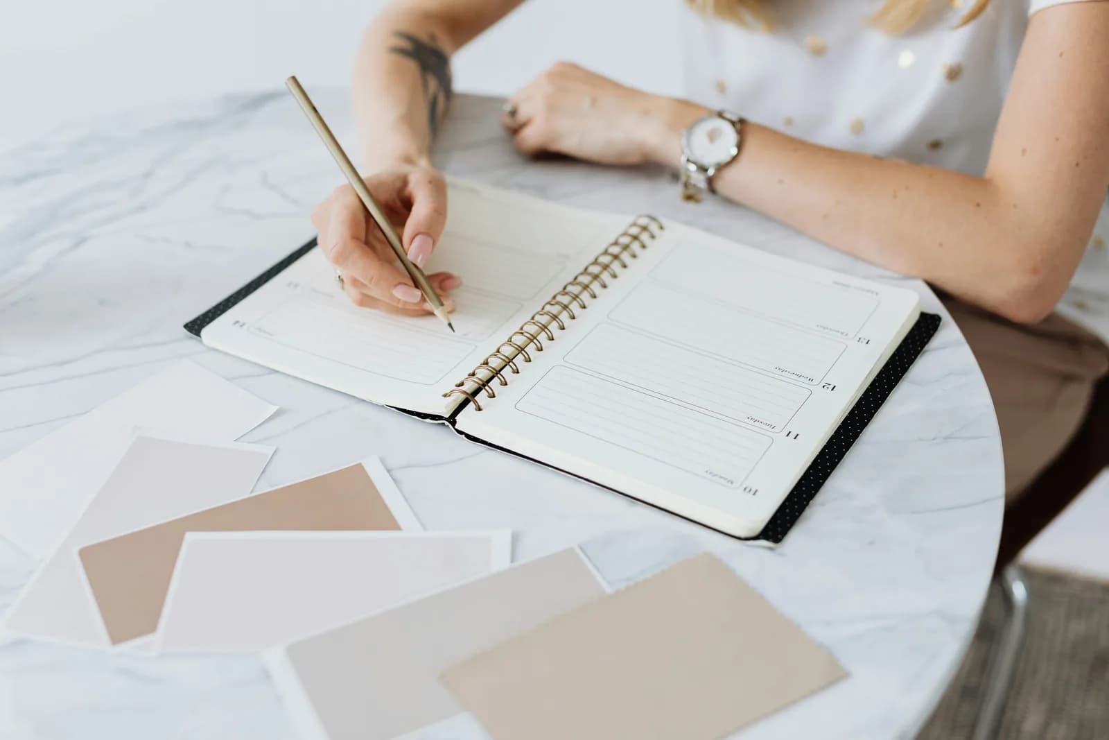 A hand holding a phone next to a paper planner, contrasting voice capture with typing