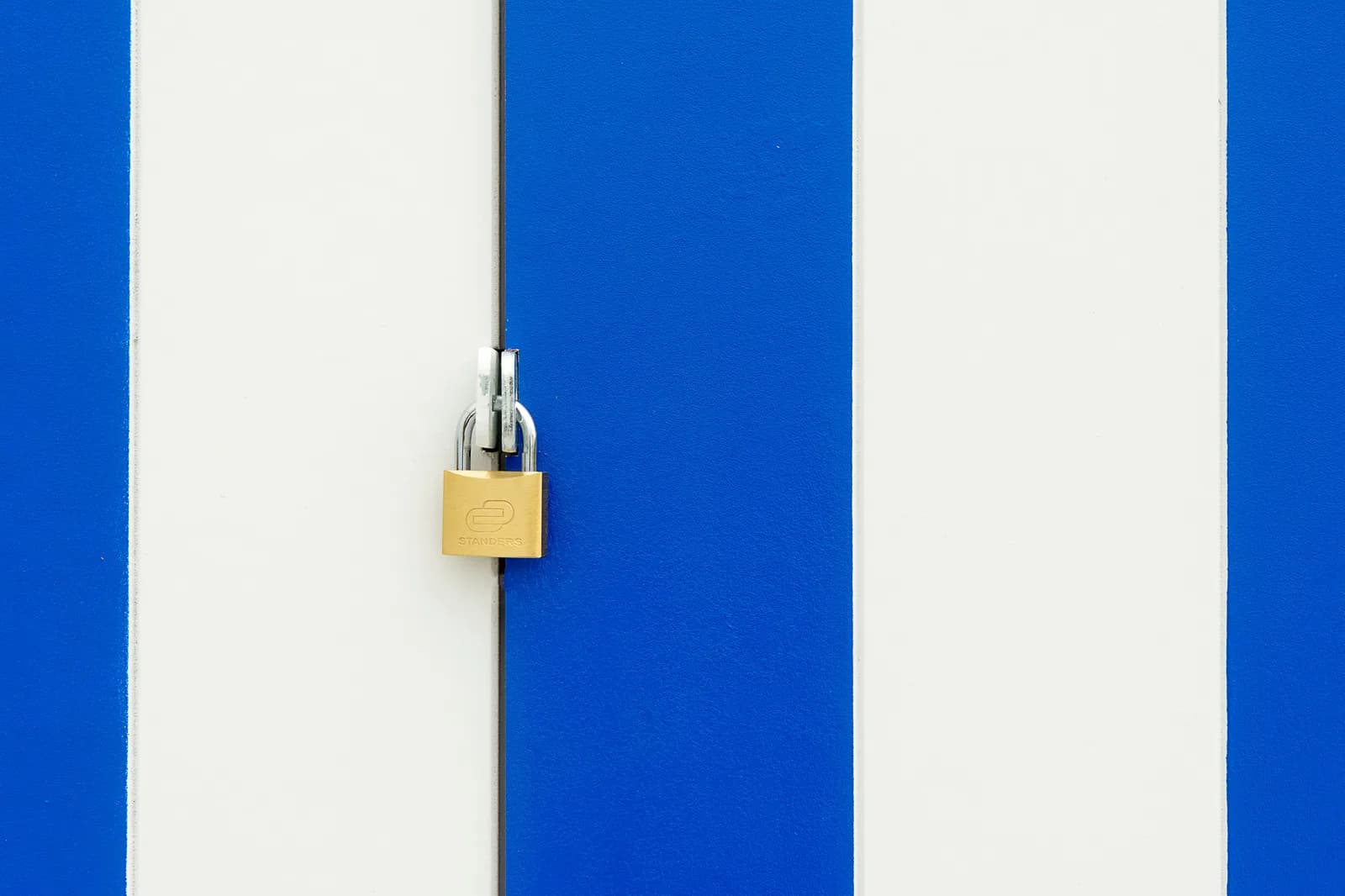 Padlock securing a blue and white striped door, symbolizing private dictation kept on your own machine