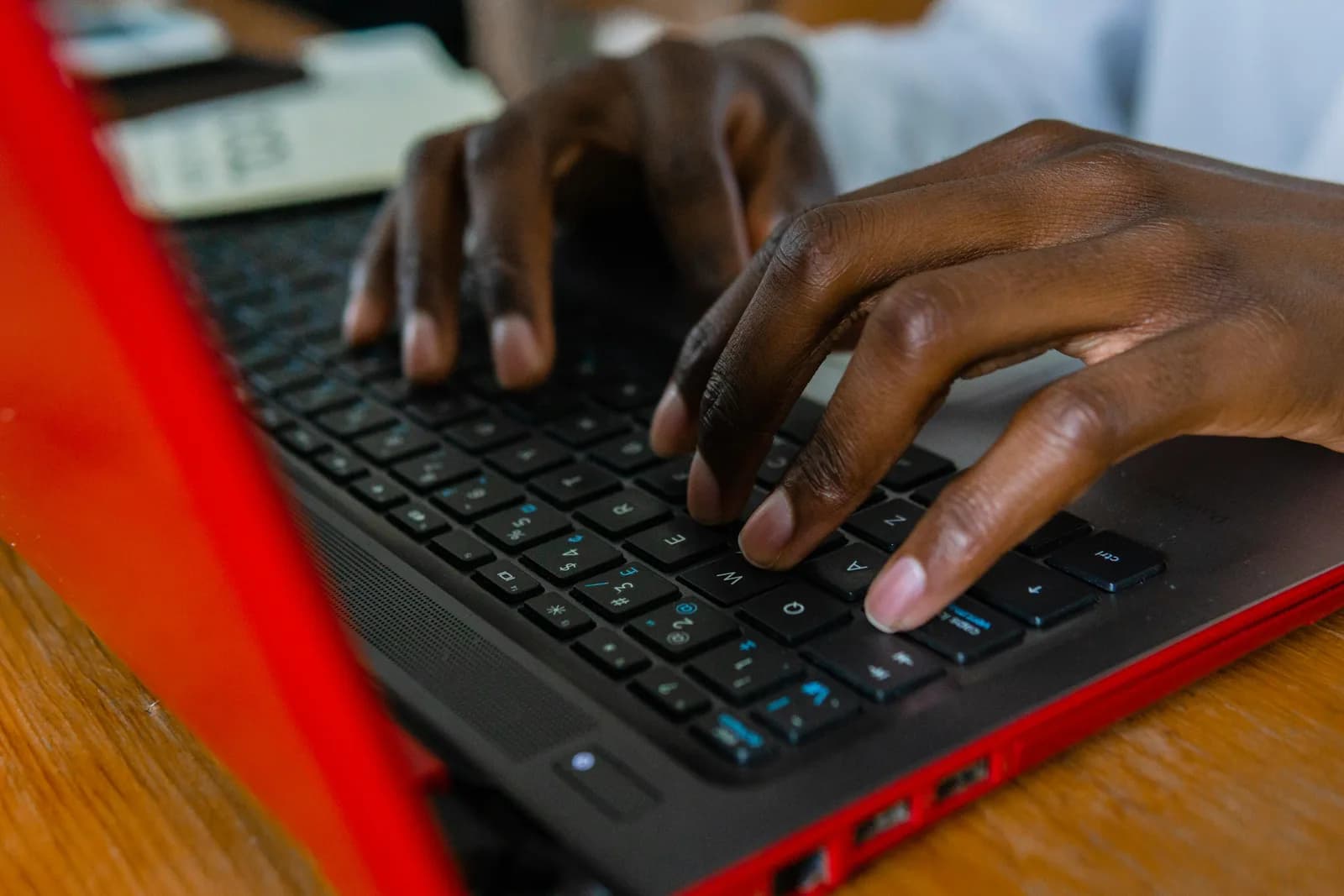 Close-up of hands typing on a laptop keyboard, the manual entry the block editor still expects