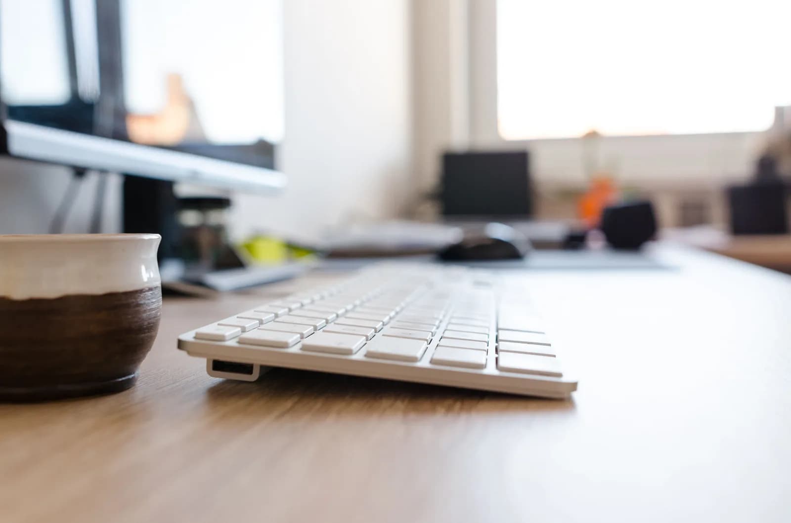Minimal office desk with a keyboard and monitor, framing a decision about which support tool to reach for