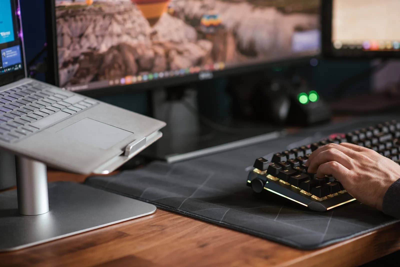 A Windows keyboard on a dark desk with the Windows key in focus, evoking the Win+H voice typing shortcut
