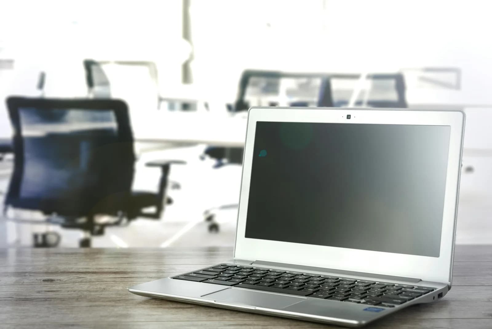 A laptop open on a desk in a bright office, ready for a settings change