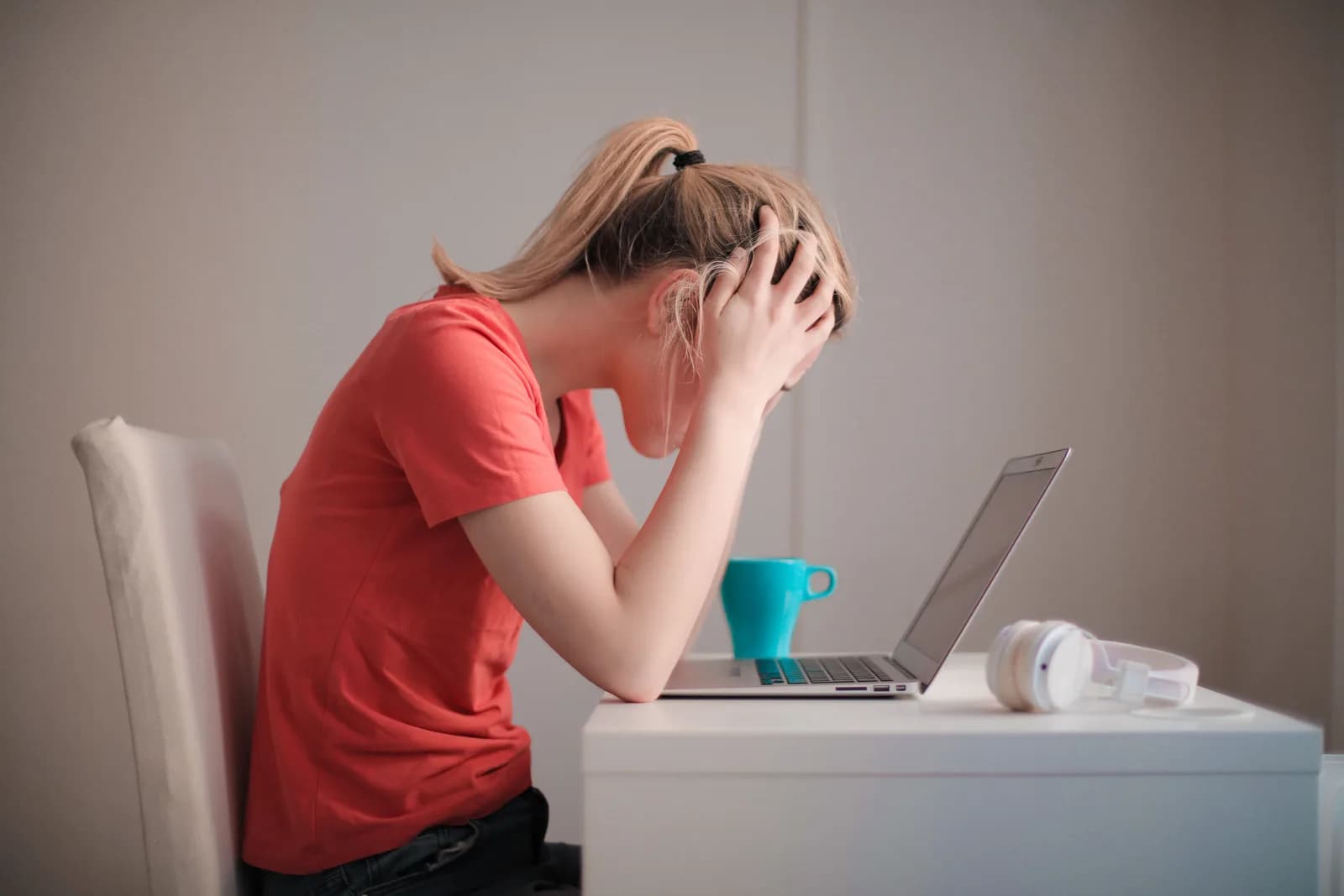 Person resting their chin on a hand while looking at a laptop, suggesting a stuck Windows feature