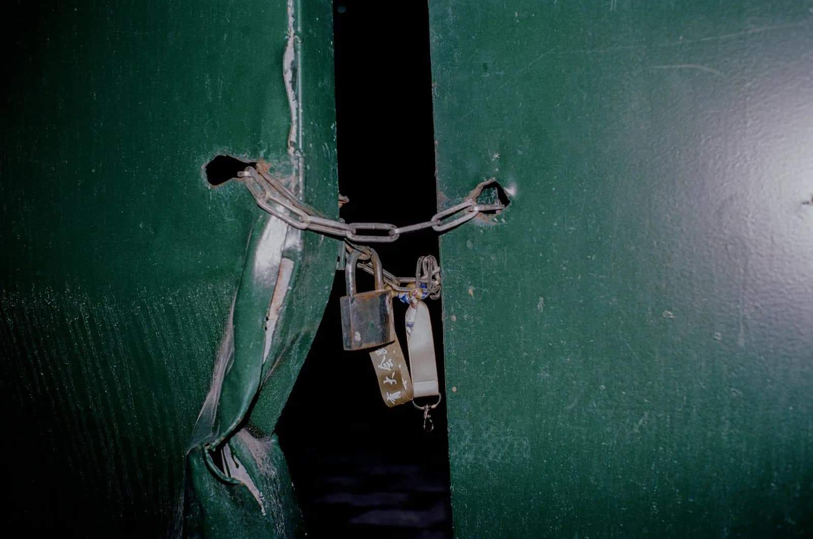 A closed wooden door secured with a heavy padlock and chain, suggesting features locked behind a vendor-managed wall