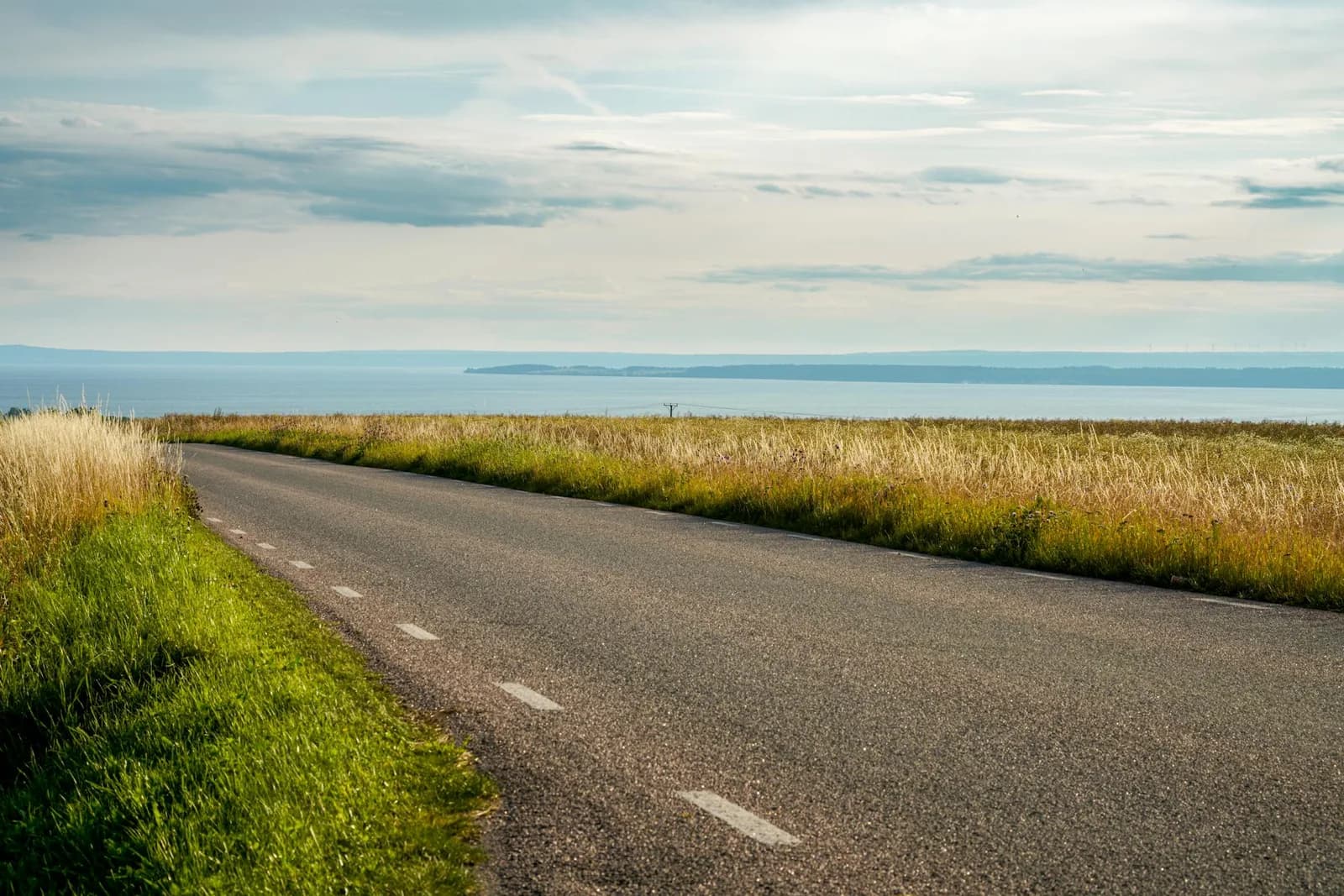 An open country road curving toward a distant horizon at dusk, suggesting a different but valid direction someone might prefer