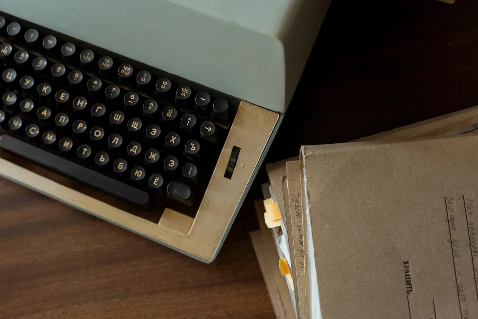 Vintage typewriter beside stacked paper documents, evoking deliberately typing each punctuation mark