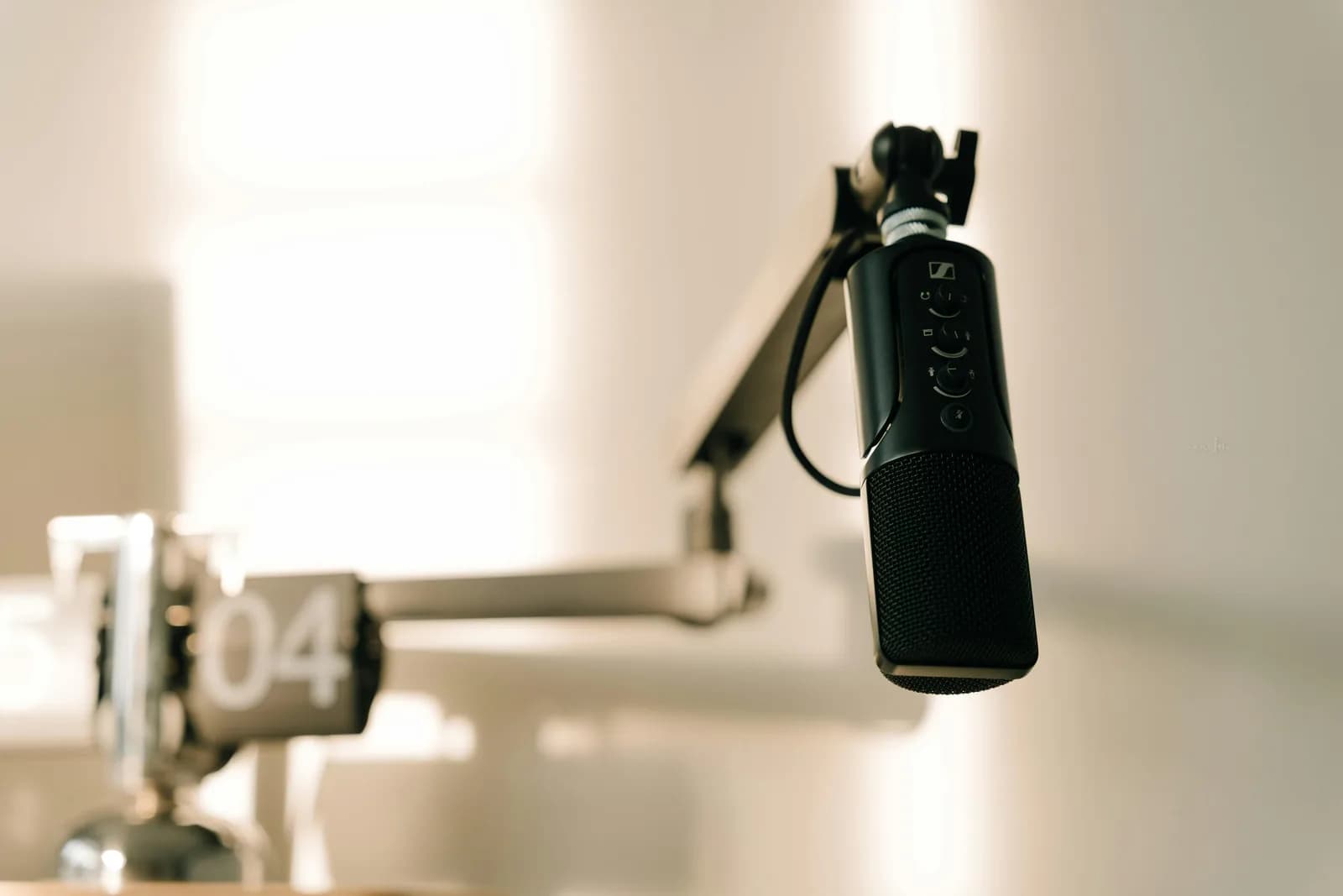 Sleek microphone on a boom arm in a minimalist studio, a clean recording-first setup