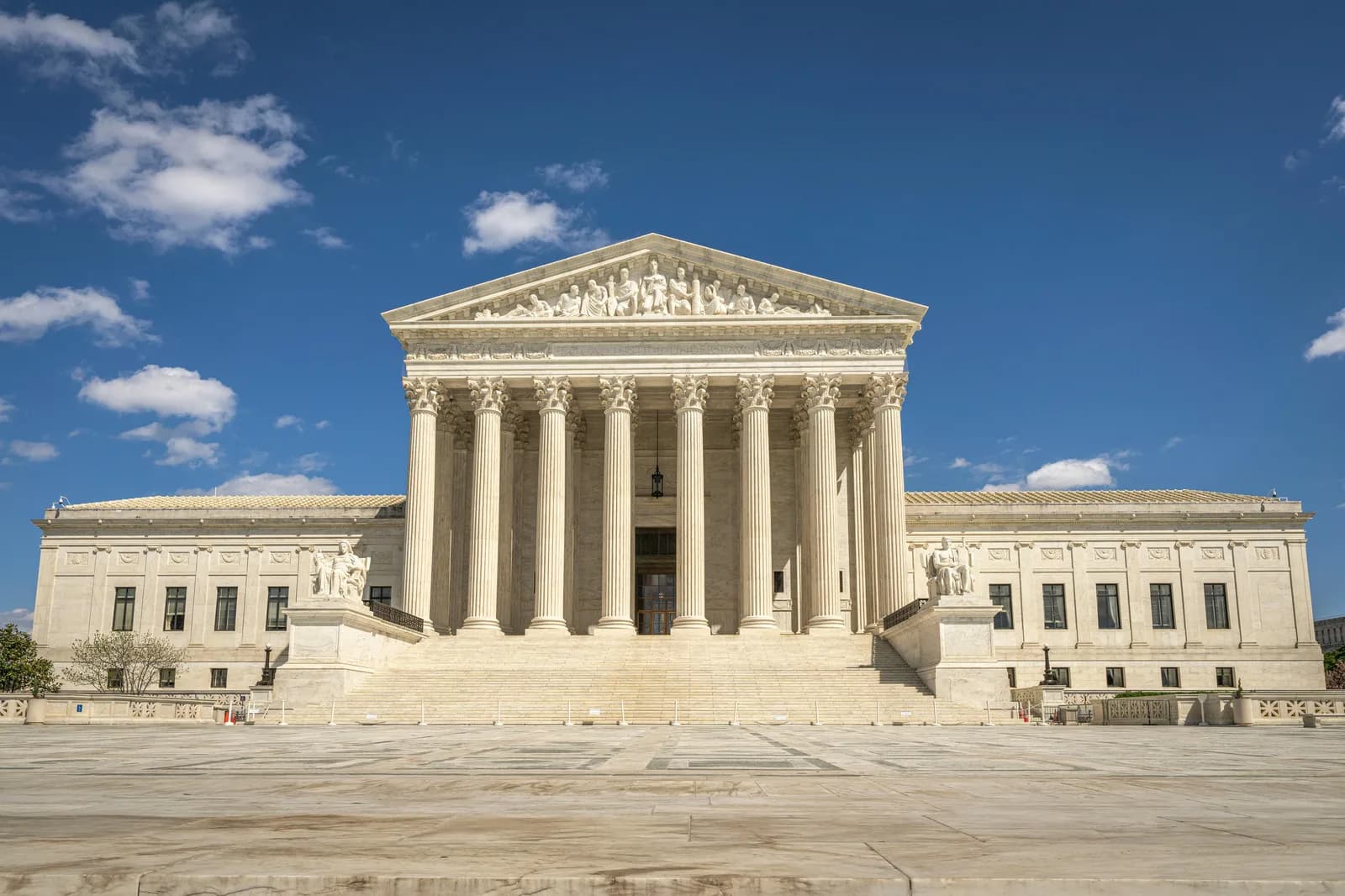 Exterior columns of a courthouse against a clear sky, suggesting formal legal proceedings