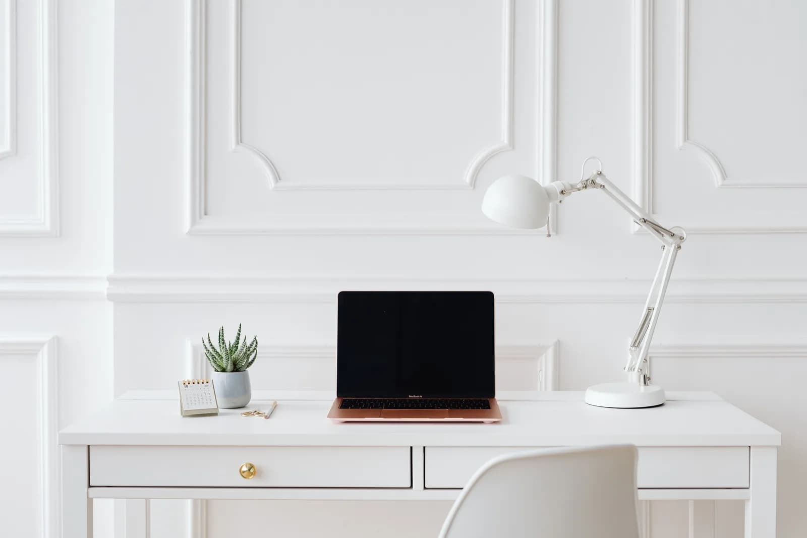 A calm, tidy desk with a MacBook in soft morning light, suggesting a problem resolved