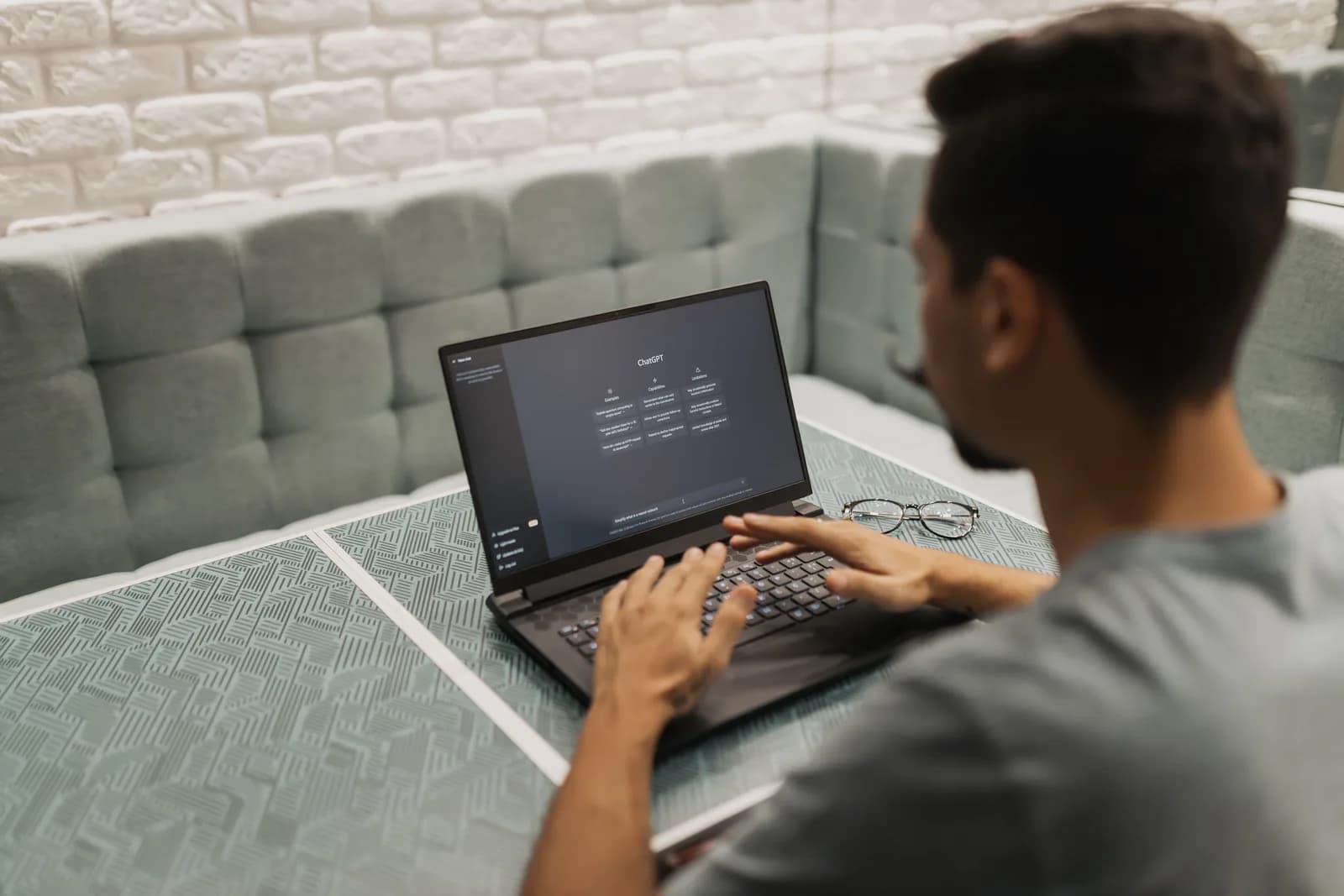 Person working at a laptop in a cozy room, adjusting software preferences such as re-enabling a dictation setting