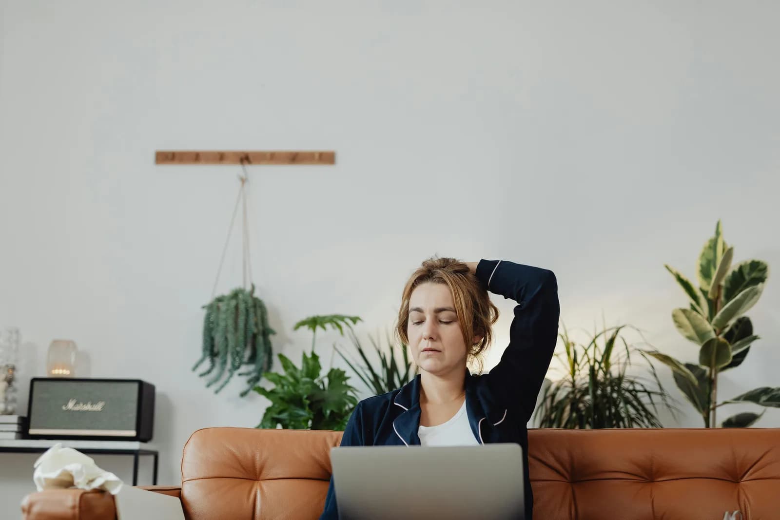 A relaxed person working at a laptop, problem solved, calm home-office setting
